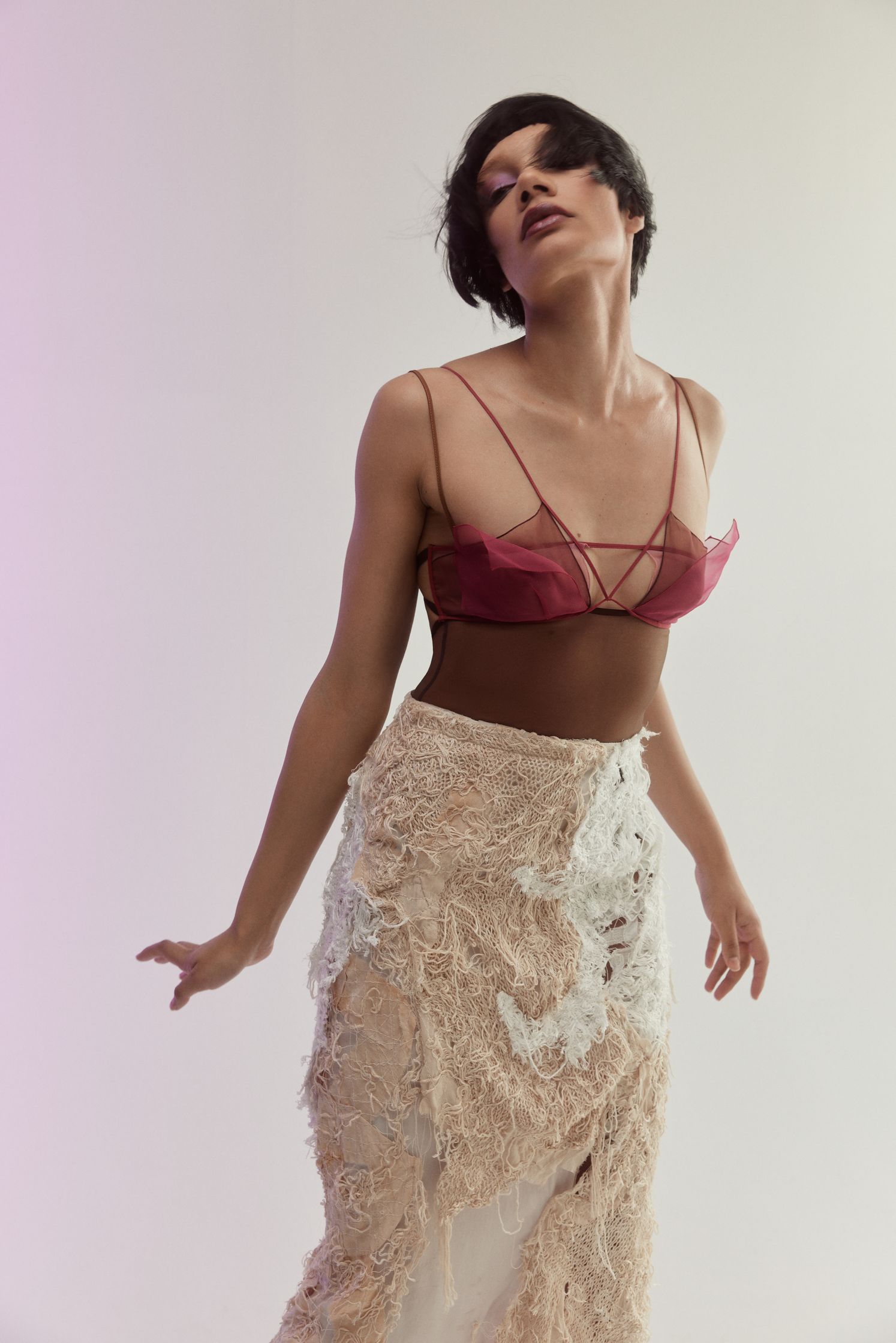 a woman is posing in a white skirt