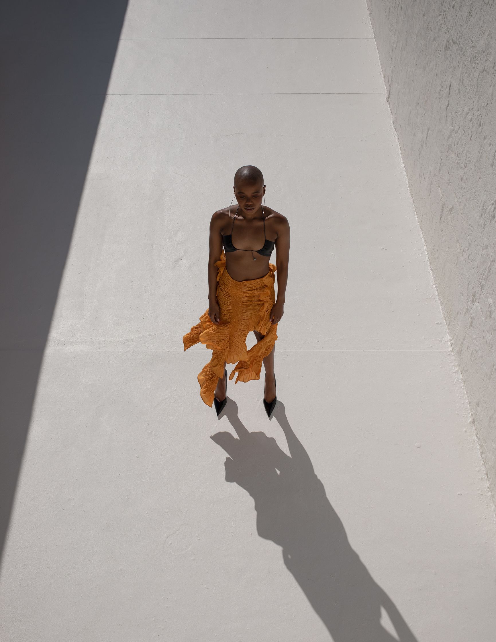 a woman in a yellow skirt standing on a white floor