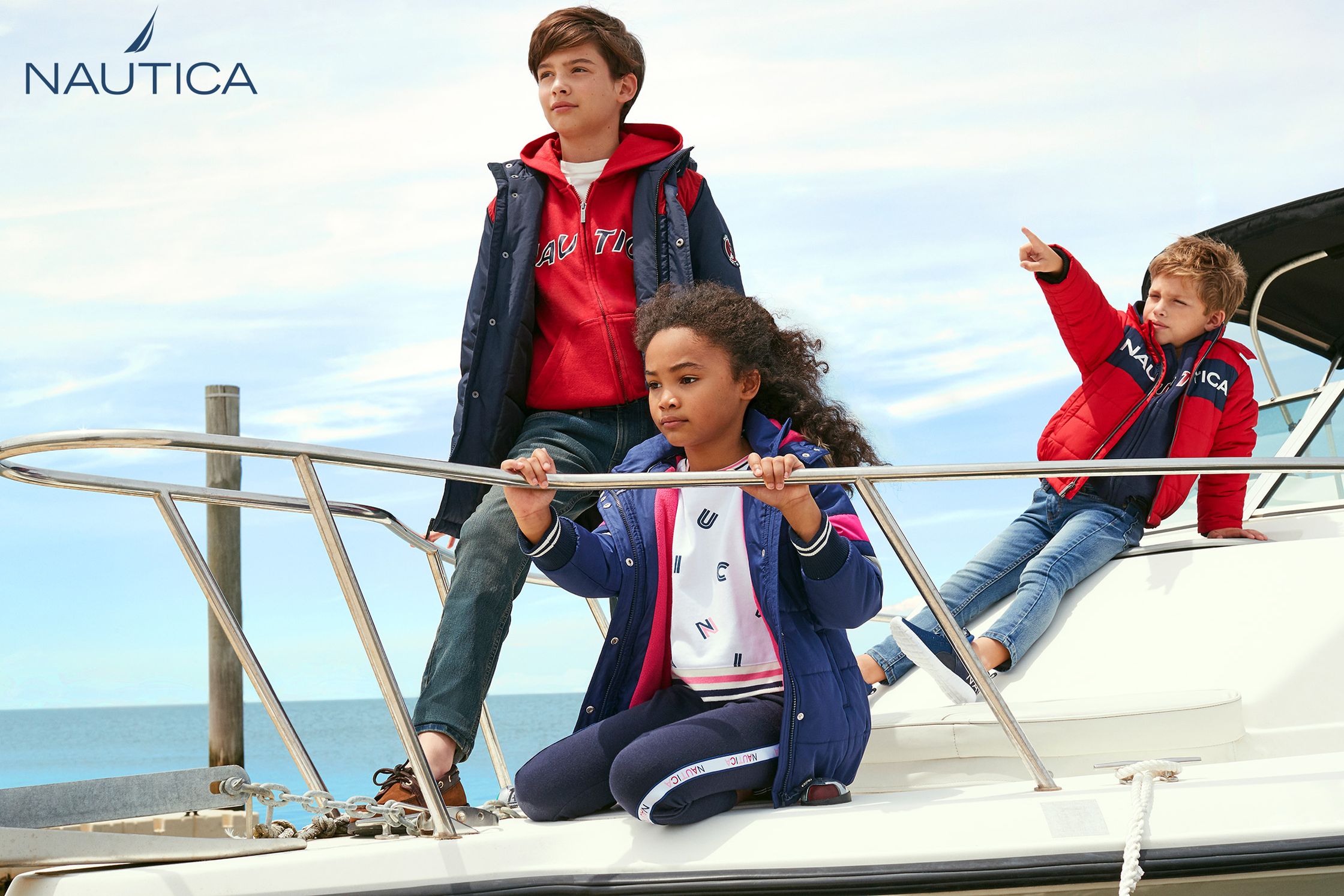 three children sitting on the deck of a boat