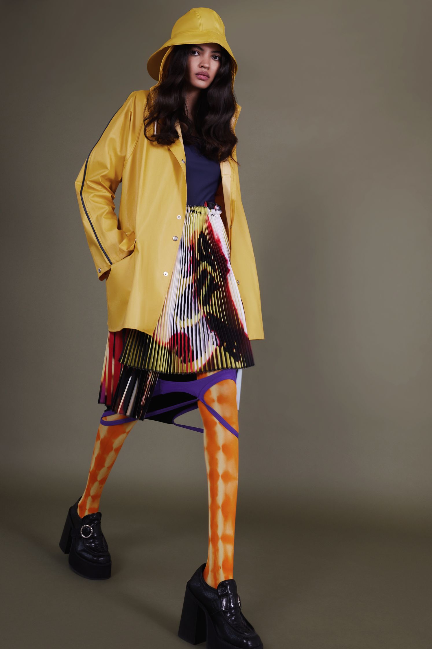 a woman wearing a yellow coat and skirt