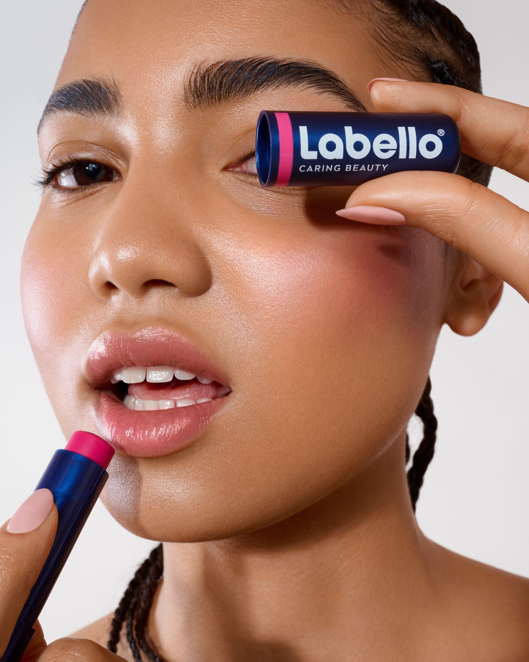 a woman is putting lipstick on her lips