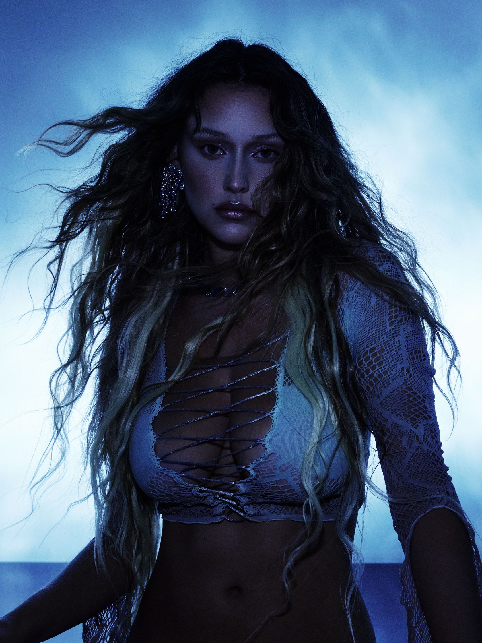 a woman in a bikini posing in front of a blue background