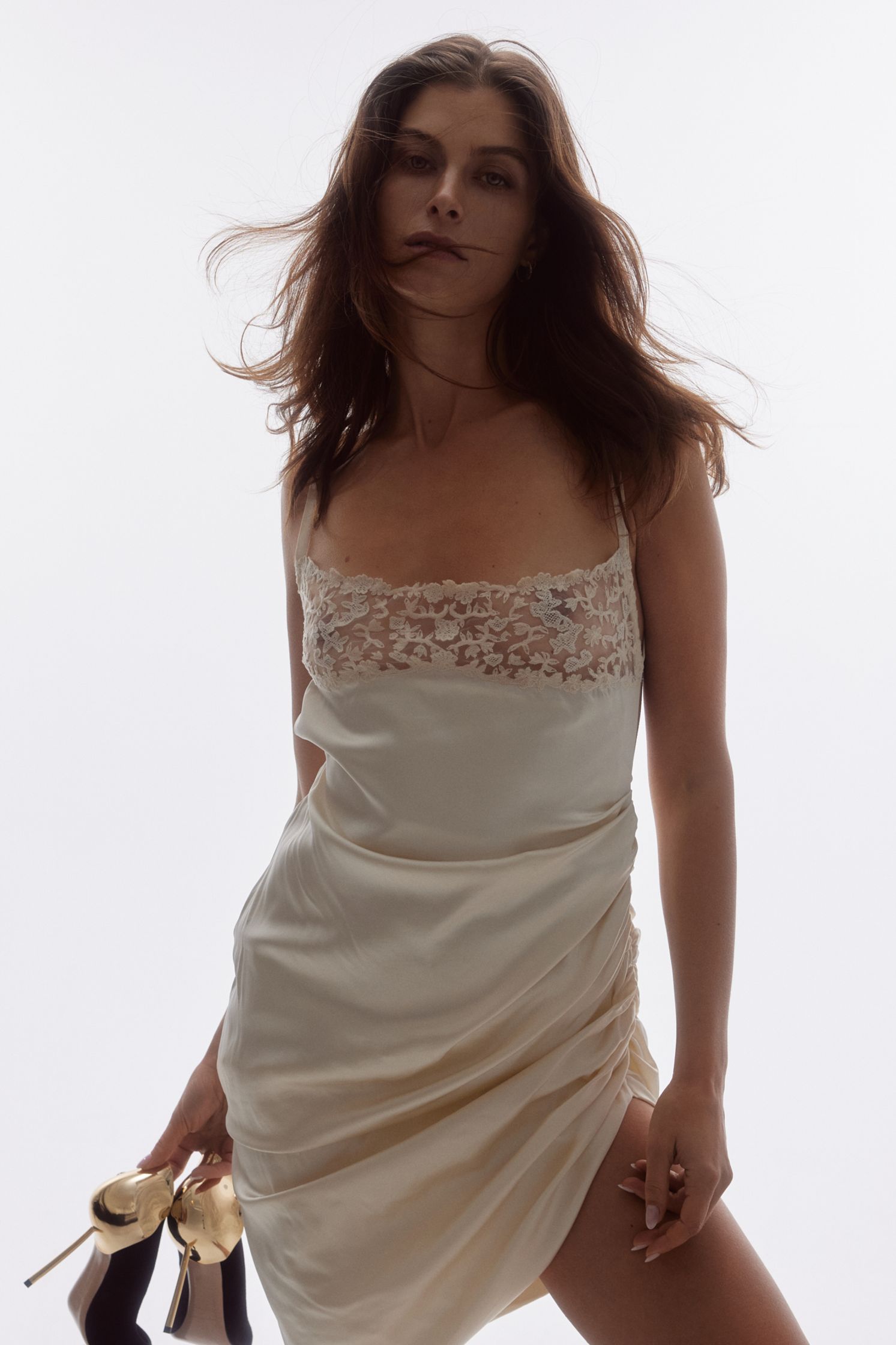 a woman in a white dress posing with high heels