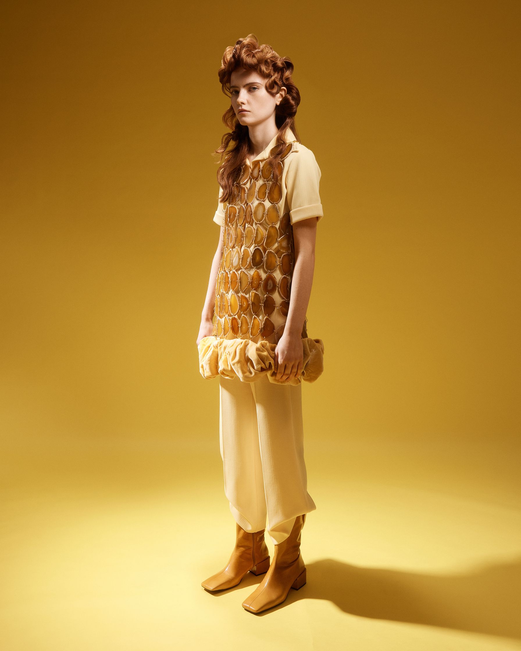 a girl in a yellow dress standing on a yellow background