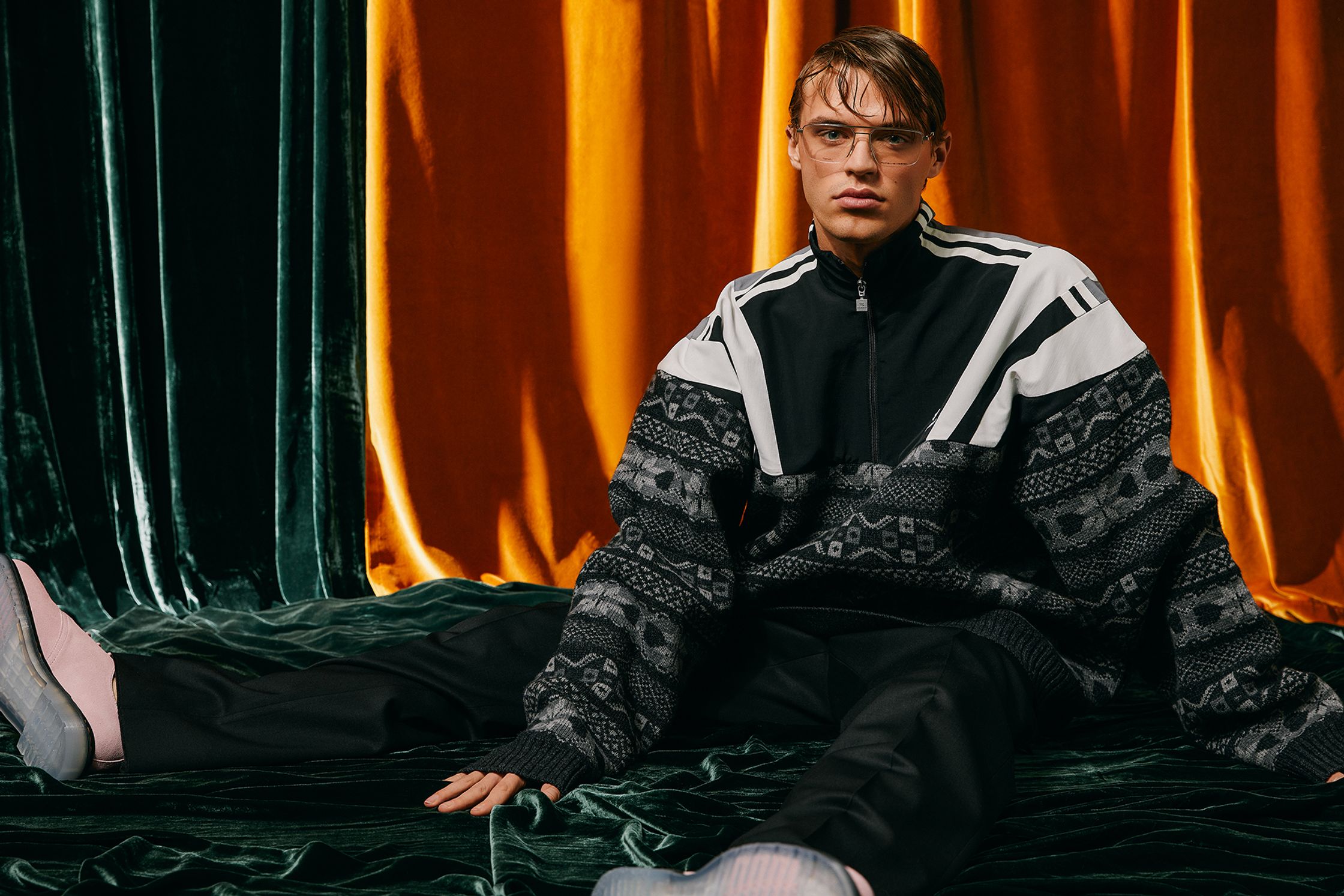 a man sitting on a couch with a pair of sneakers