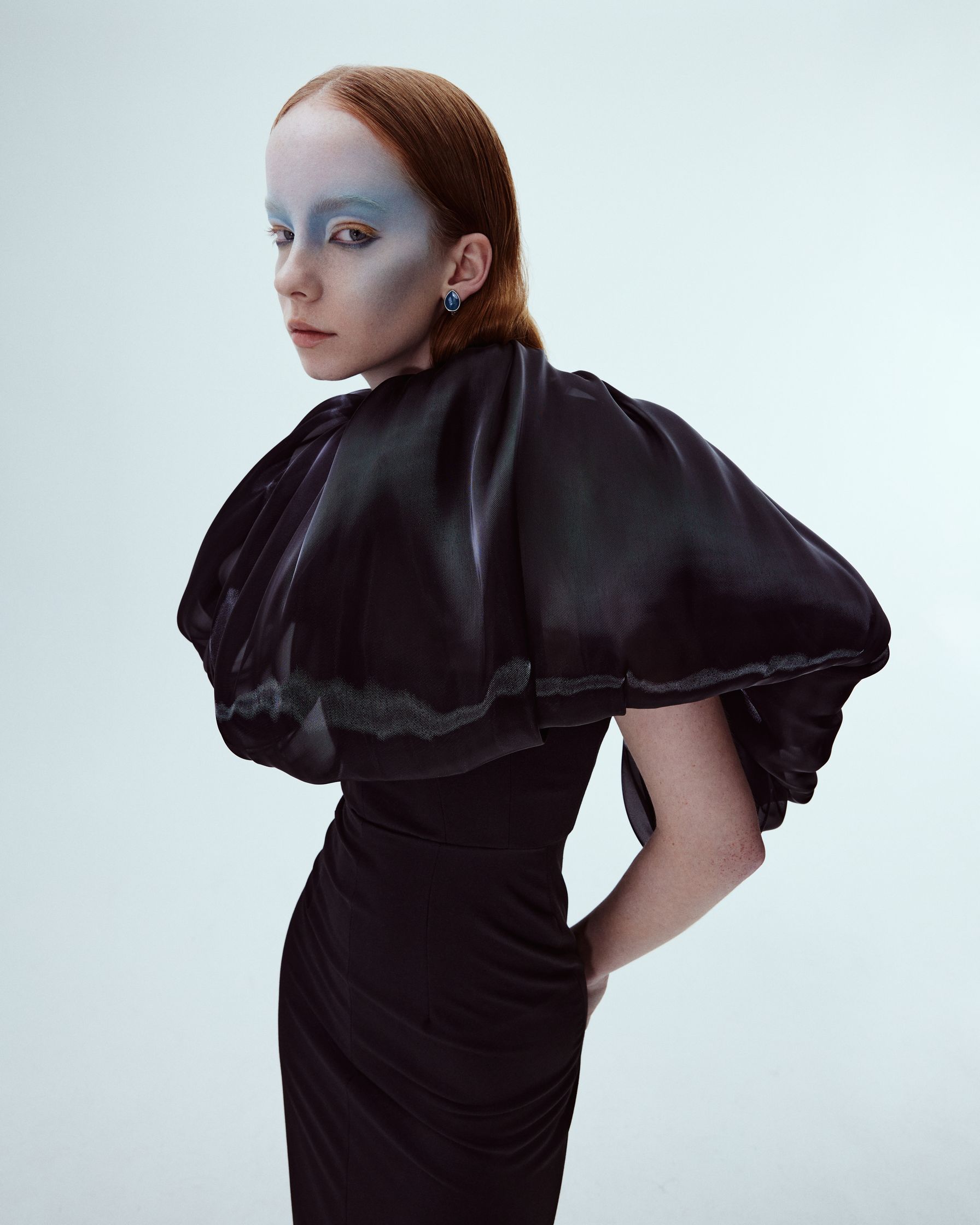 a woman in a black dress with blue makeup