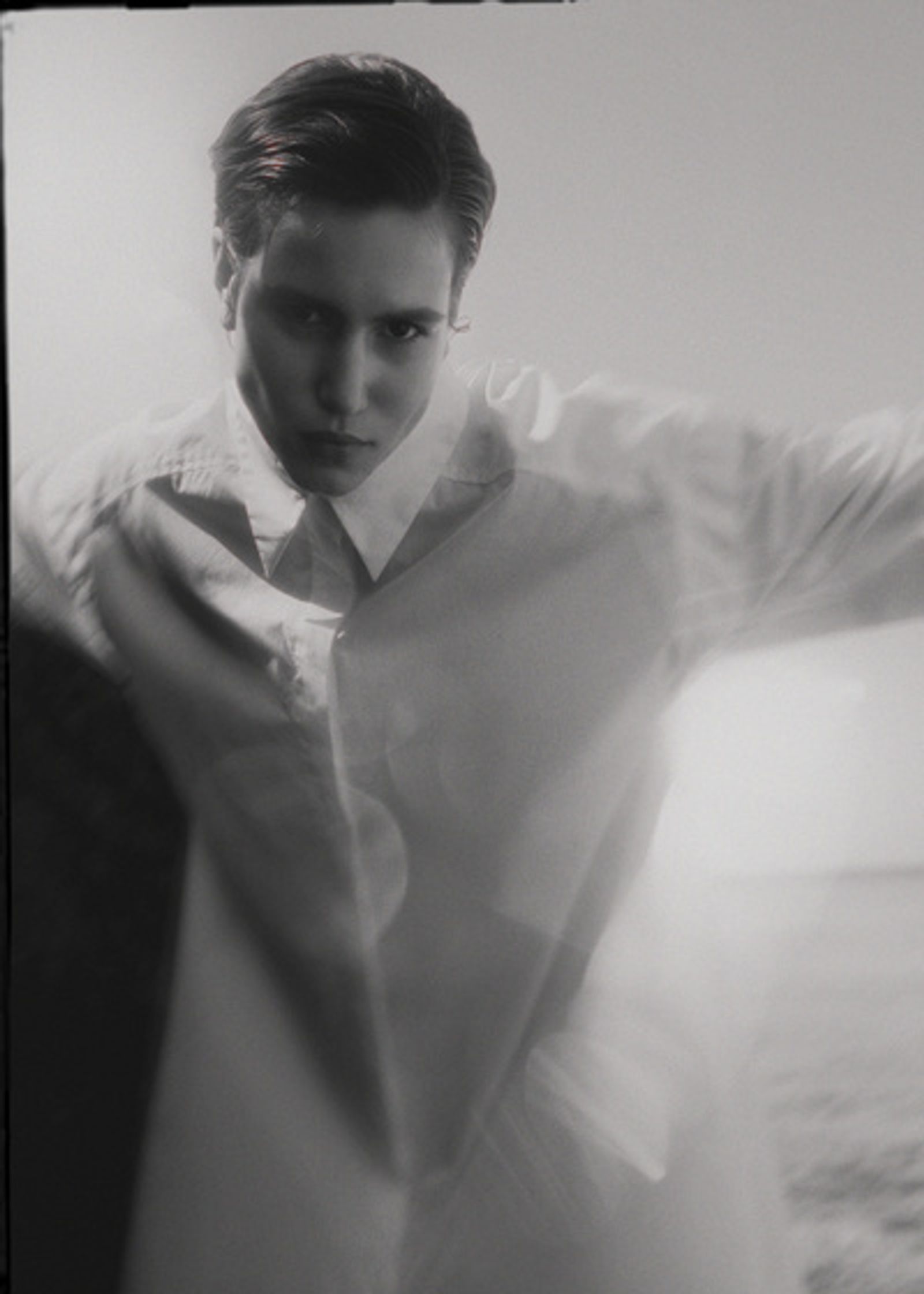 a black and white photo of a man in a white shirt
