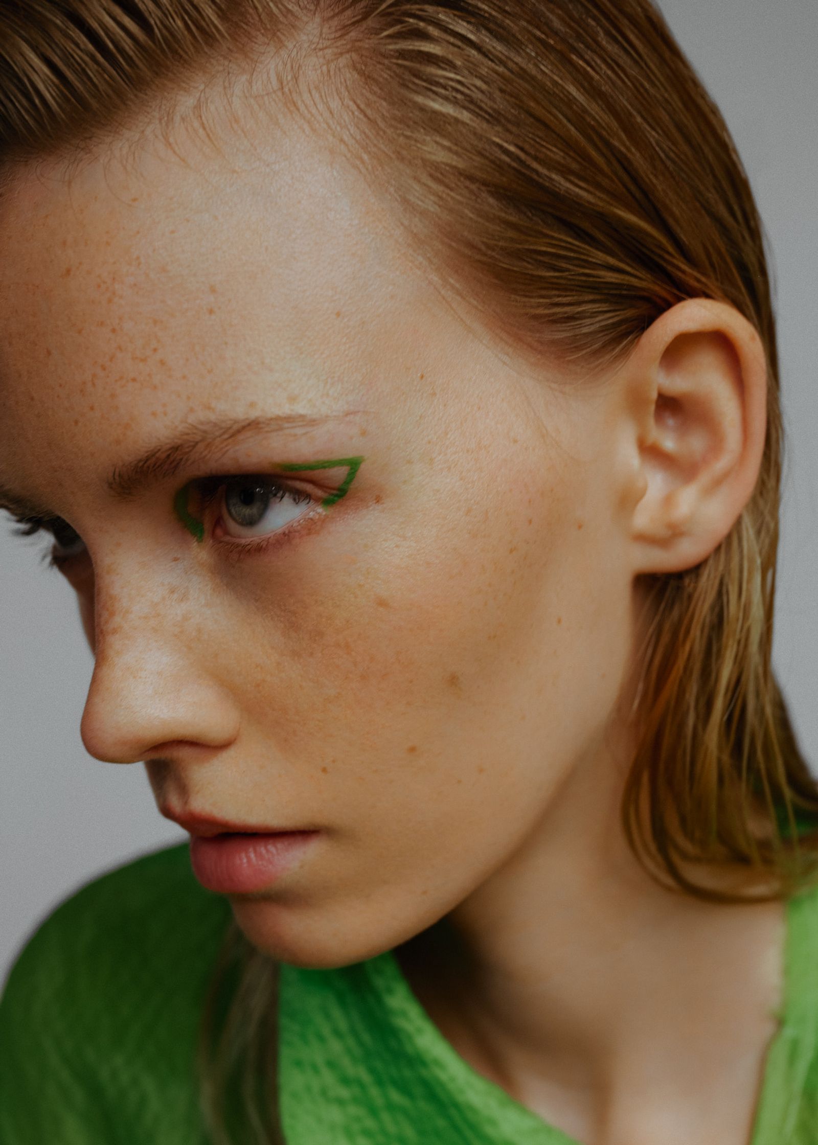 a woman with green eyes and a green shirt