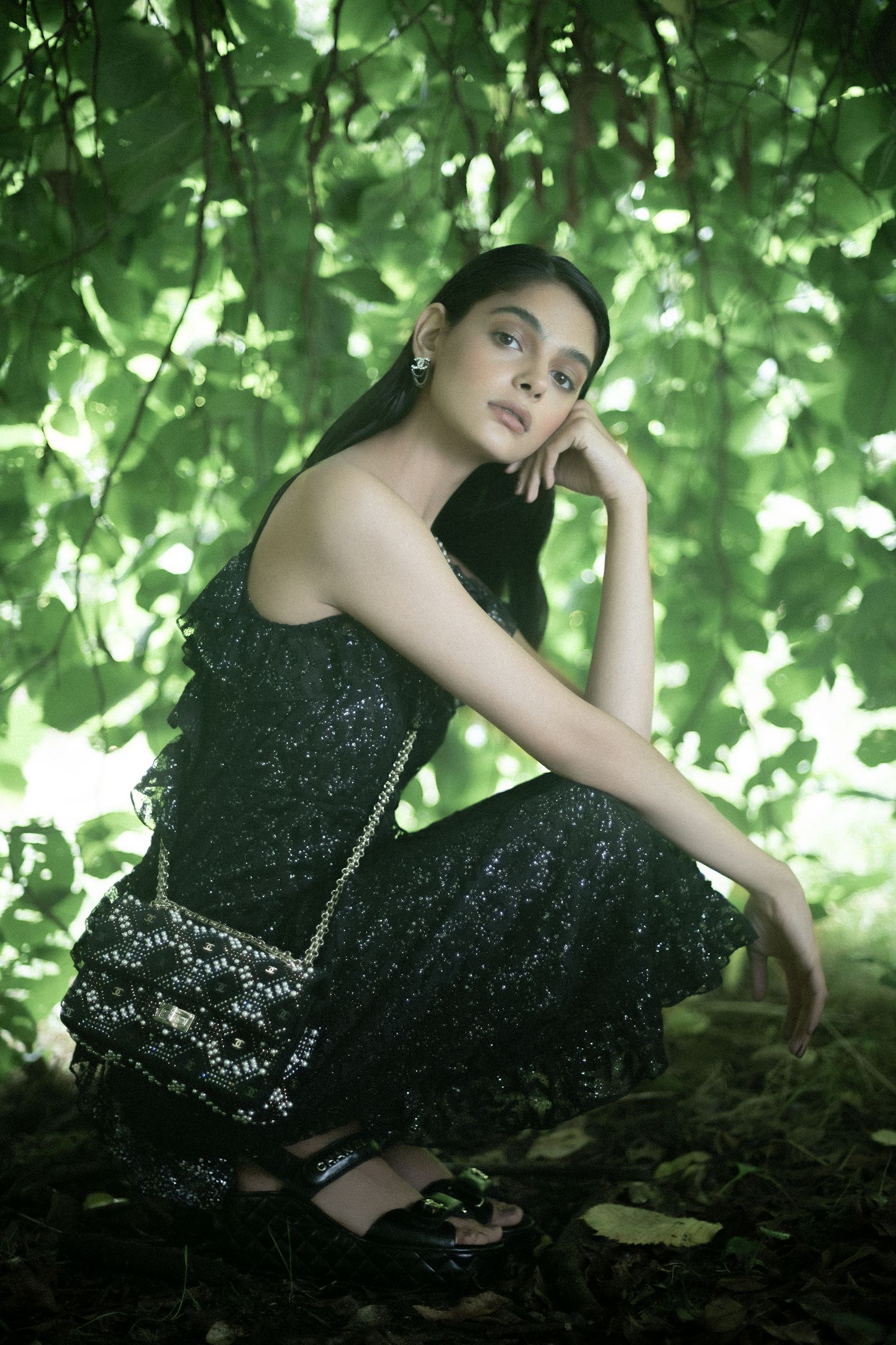 a woman in a black dress posing in the woods