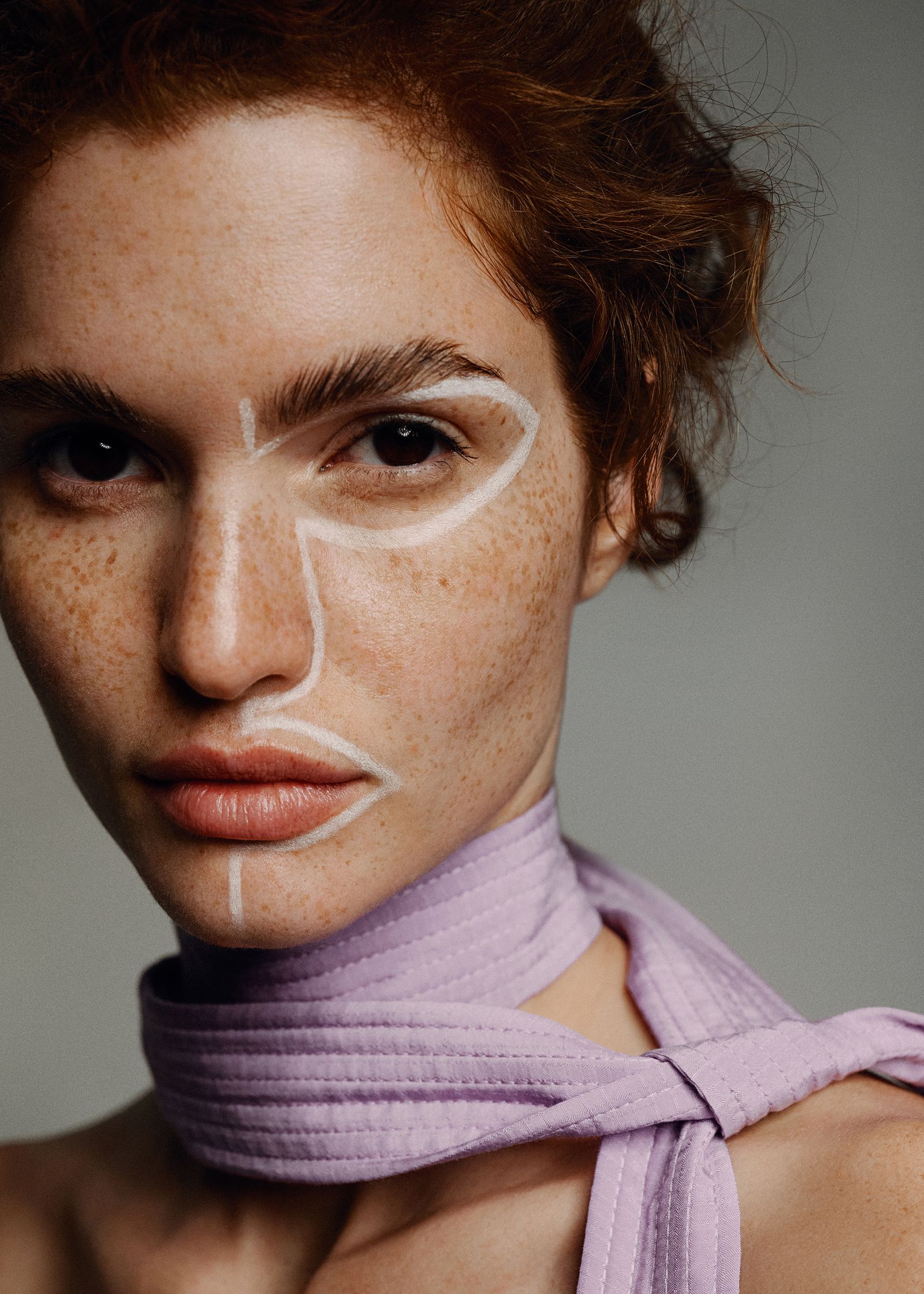 a woman with freckles wearing a purple scarf