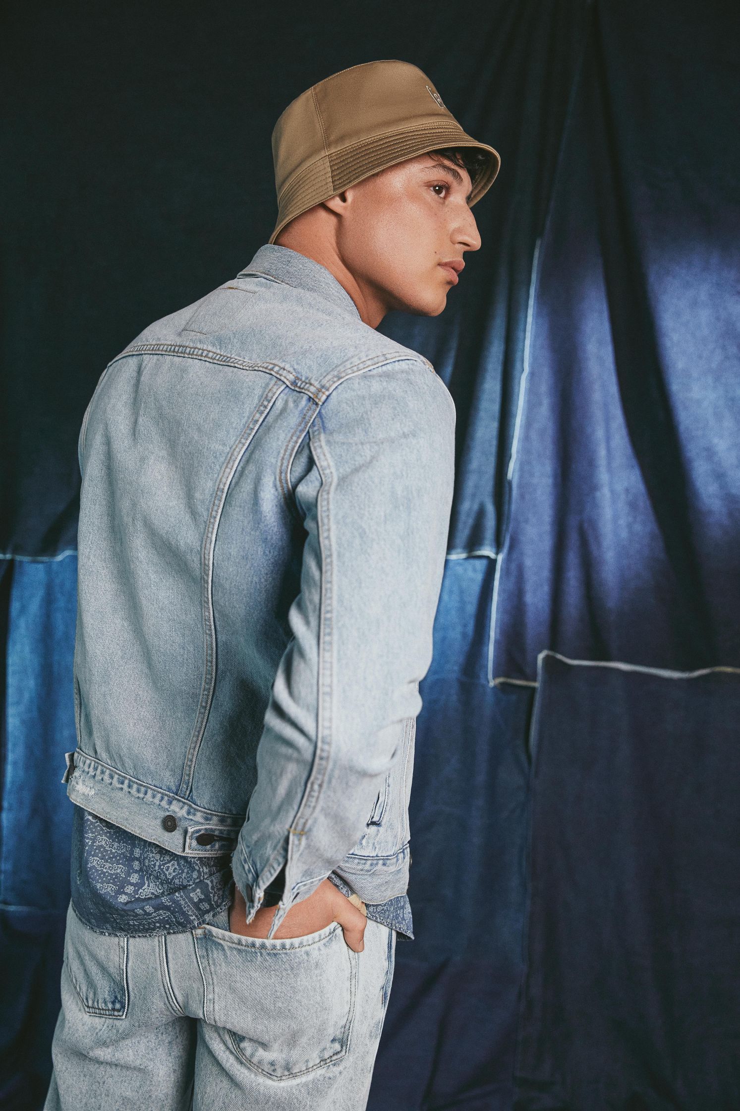 a man wearing a denim jacket and a beanie