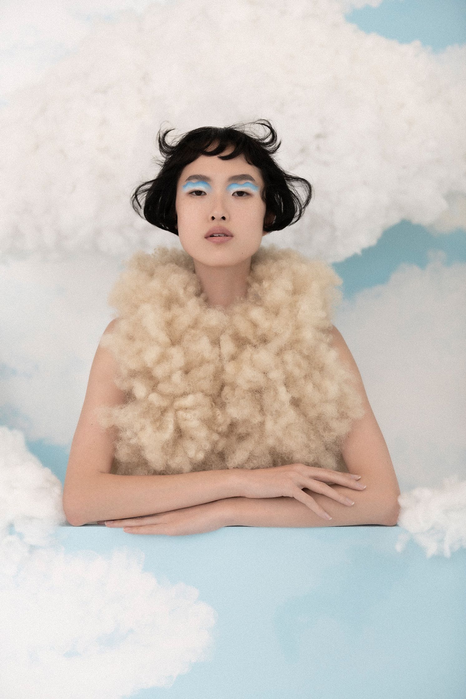 a woman is posing on top of a cloud