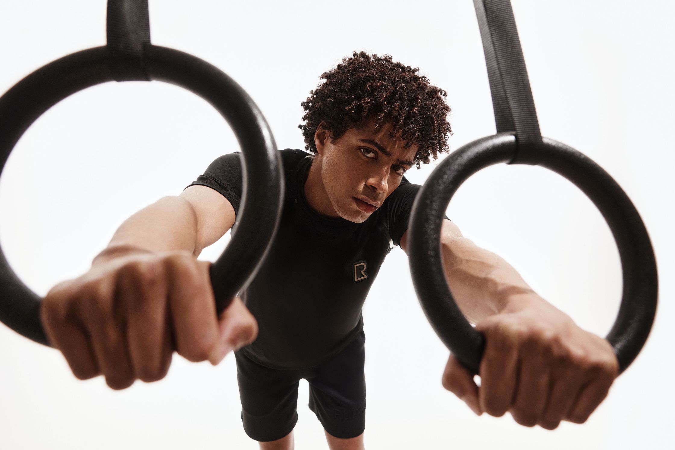 a man doing ring exercises on a white background