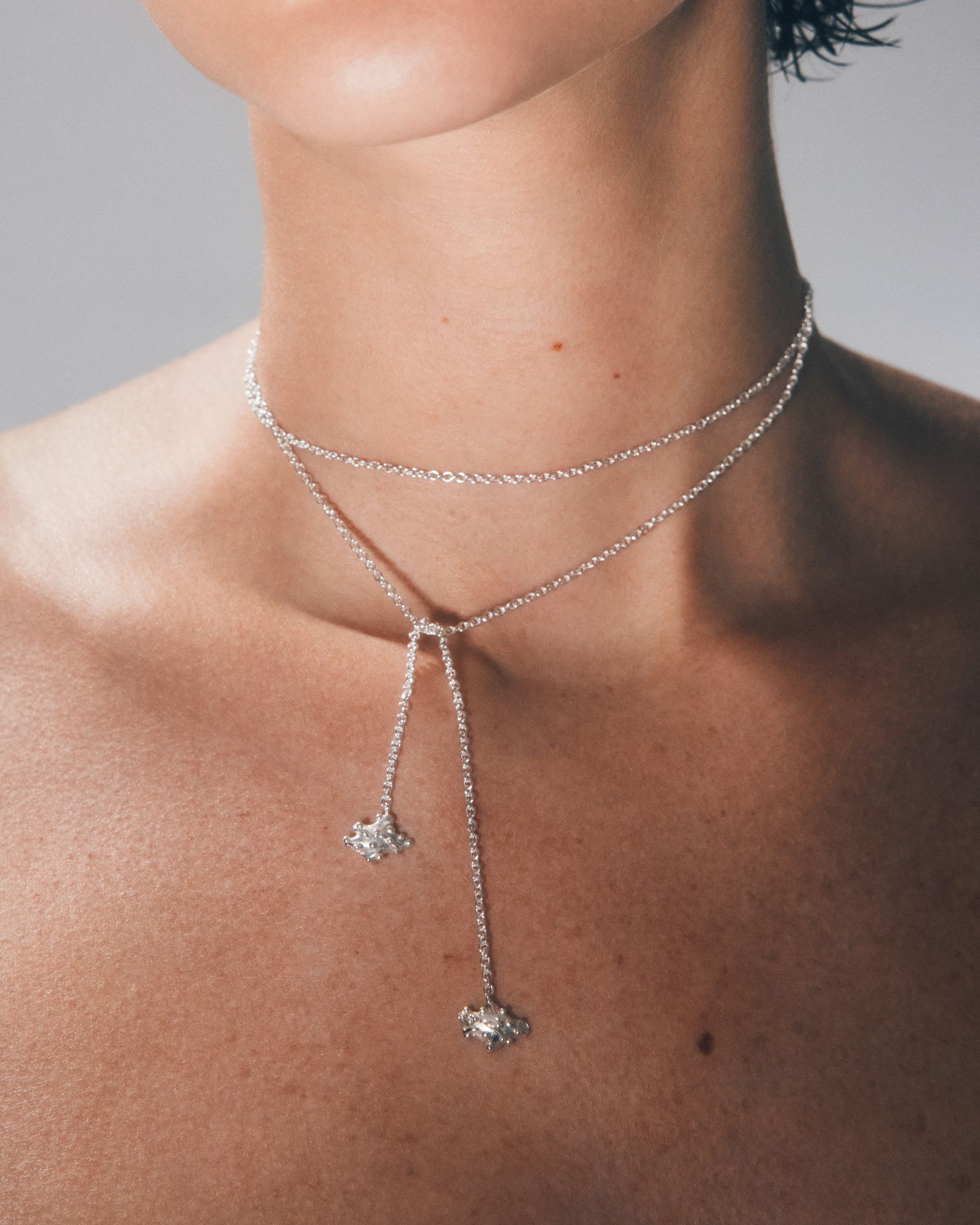 a woman wearing a silver choker necklace