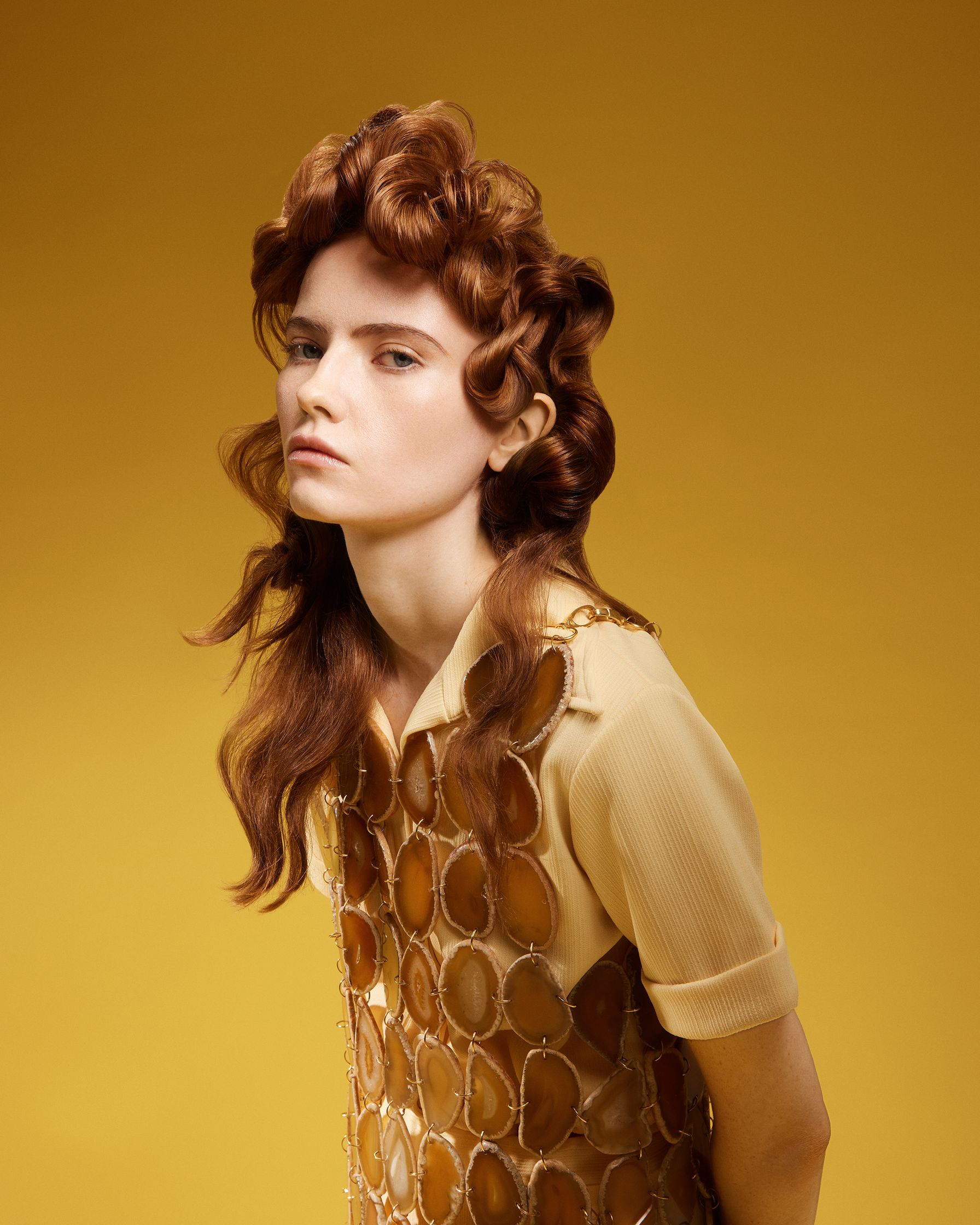 a woman in a yellow dress with curly hair