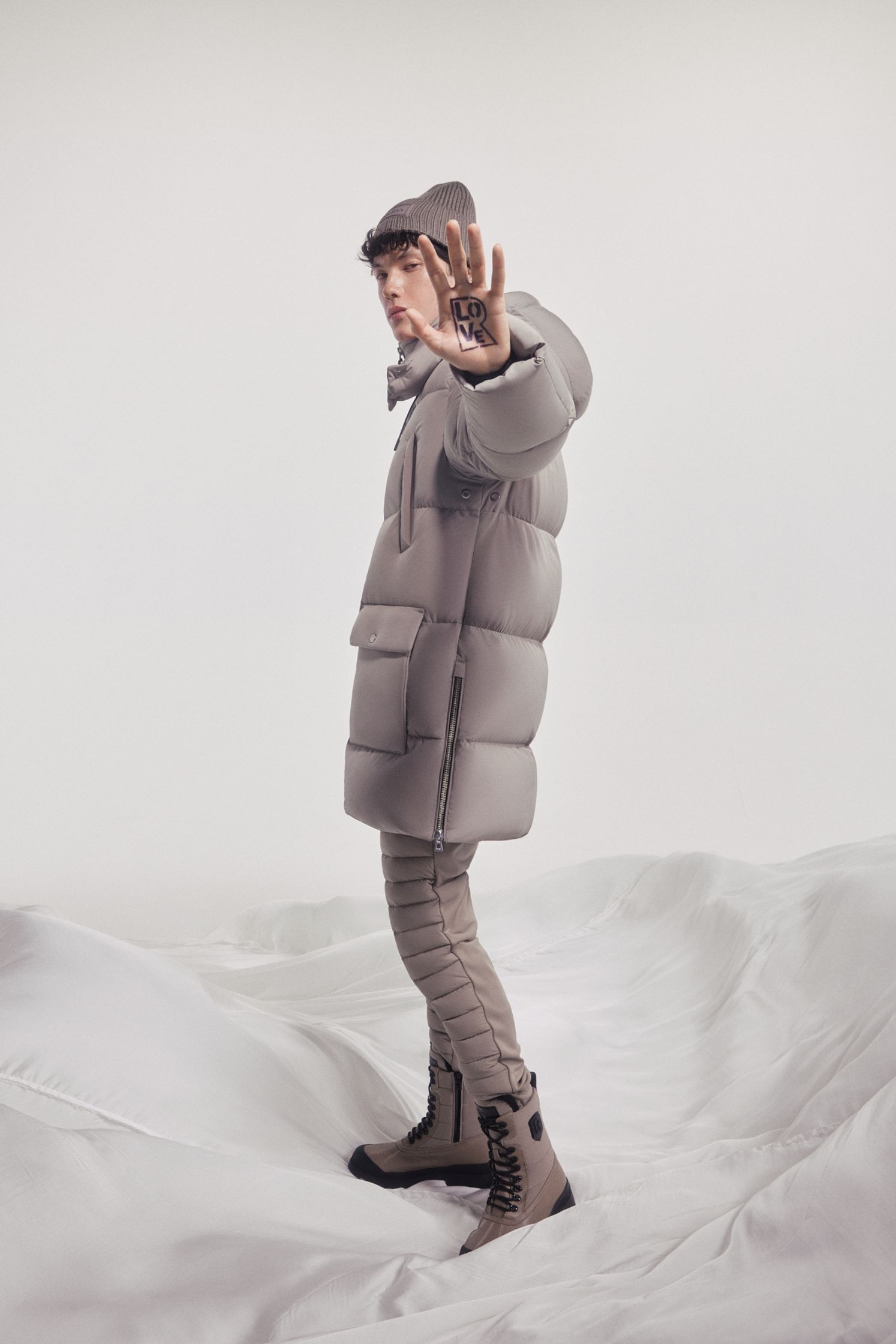 a man in a puffer jacket standing in the snow