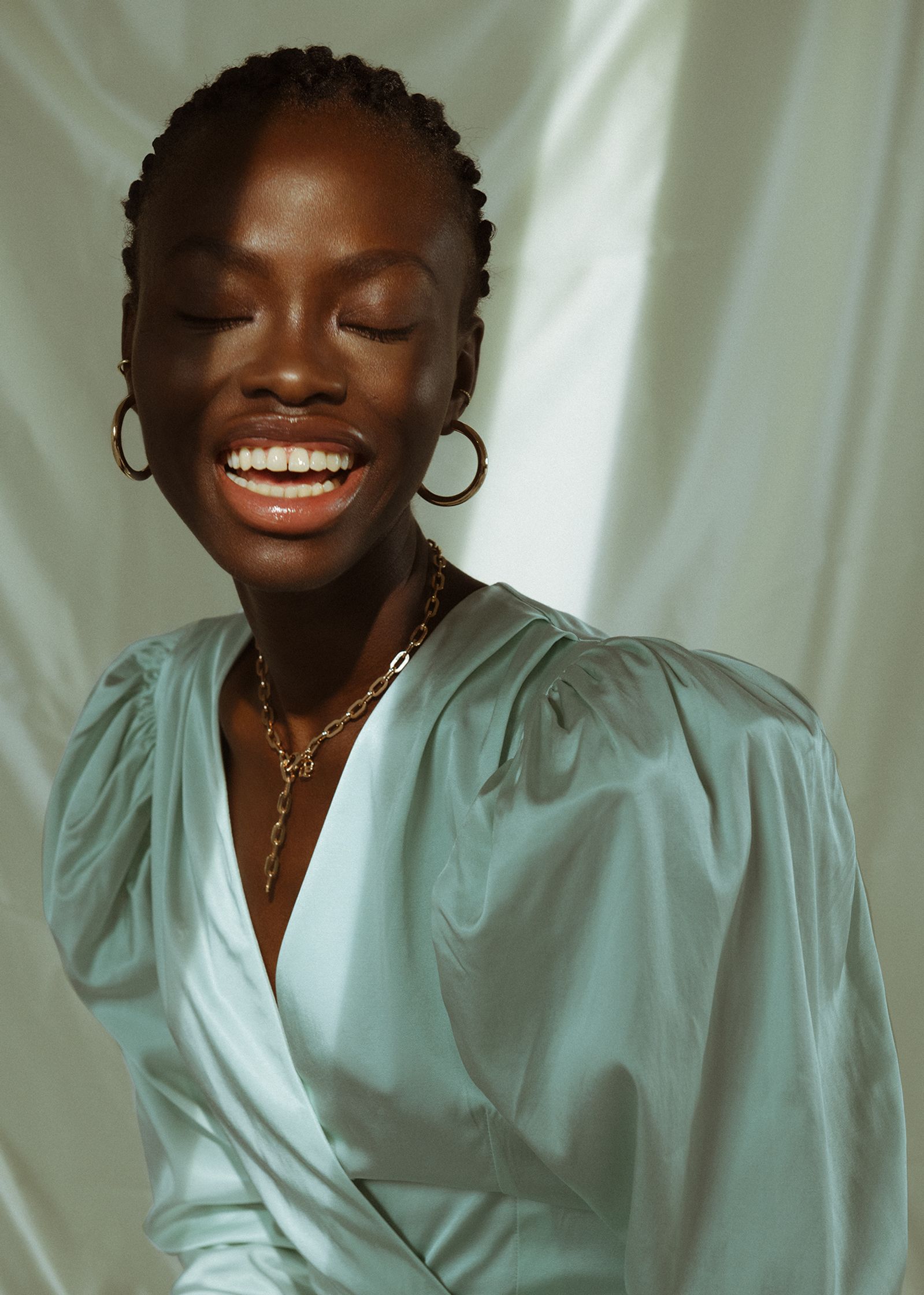 a black woman smiling in a light blue dress