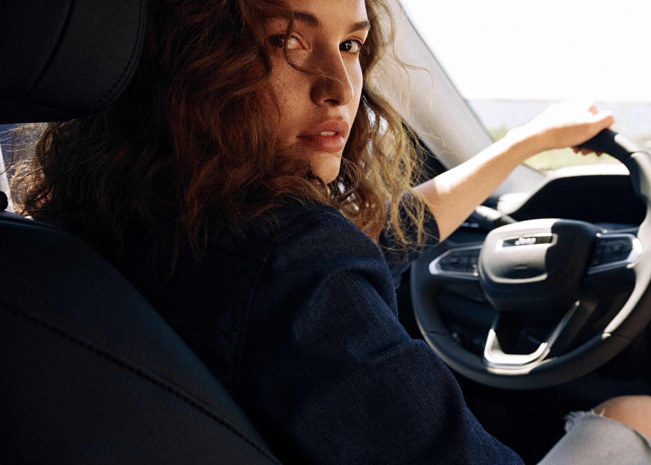 a woman sitting in the driver's seat of a car