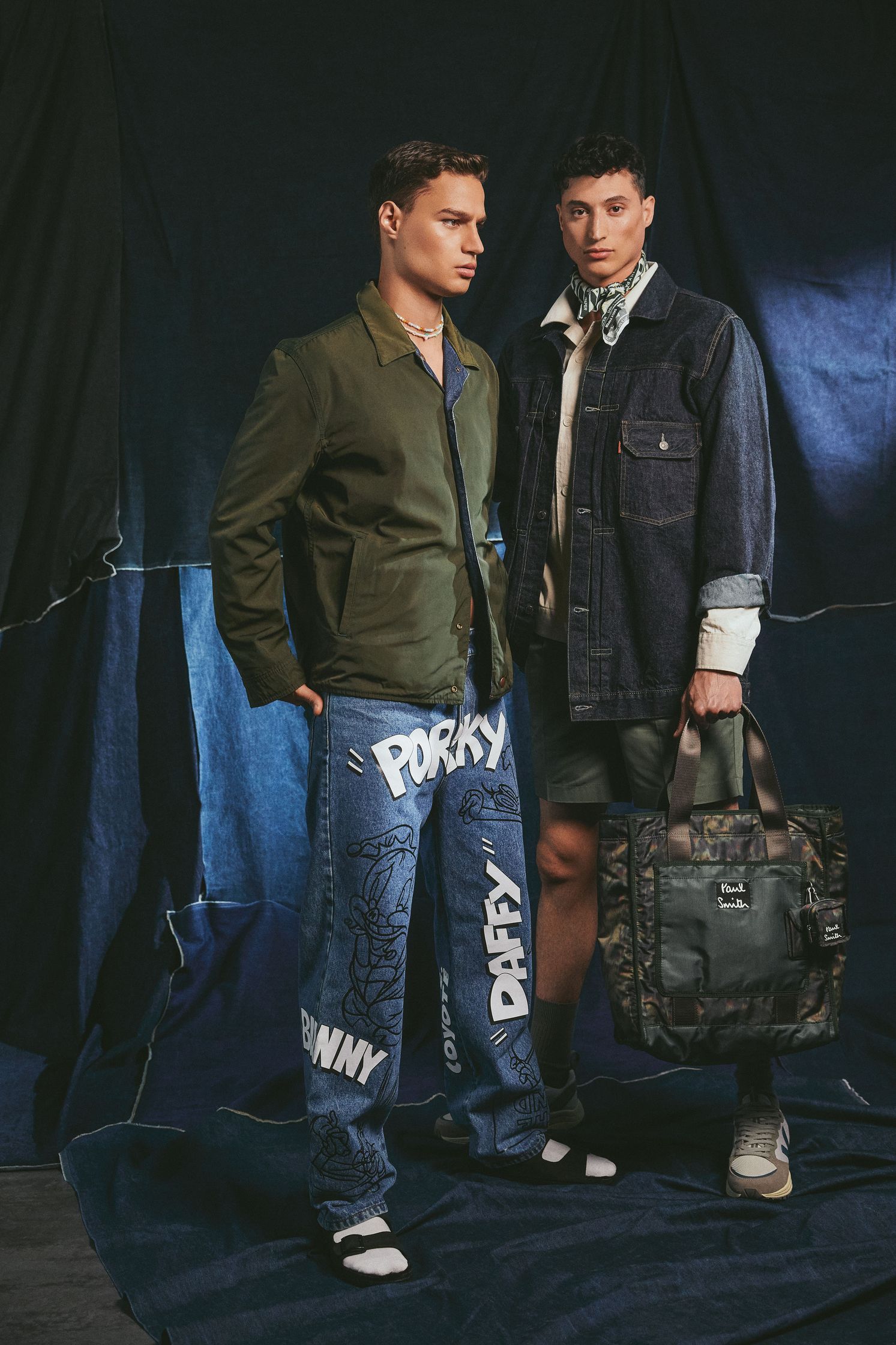 two men are posing for a photo with a bag