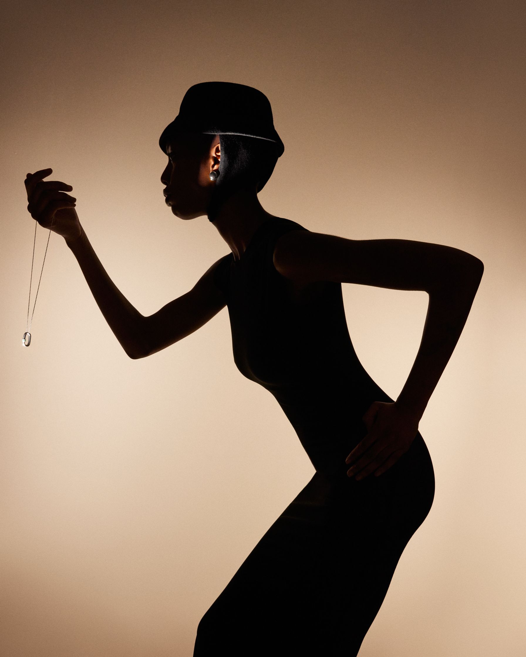 a silhouette of a woman holding a necklace