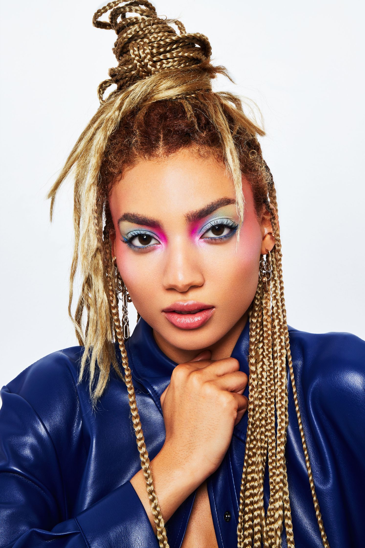 a woman in a blue leather jacket with colorful dreadlocks