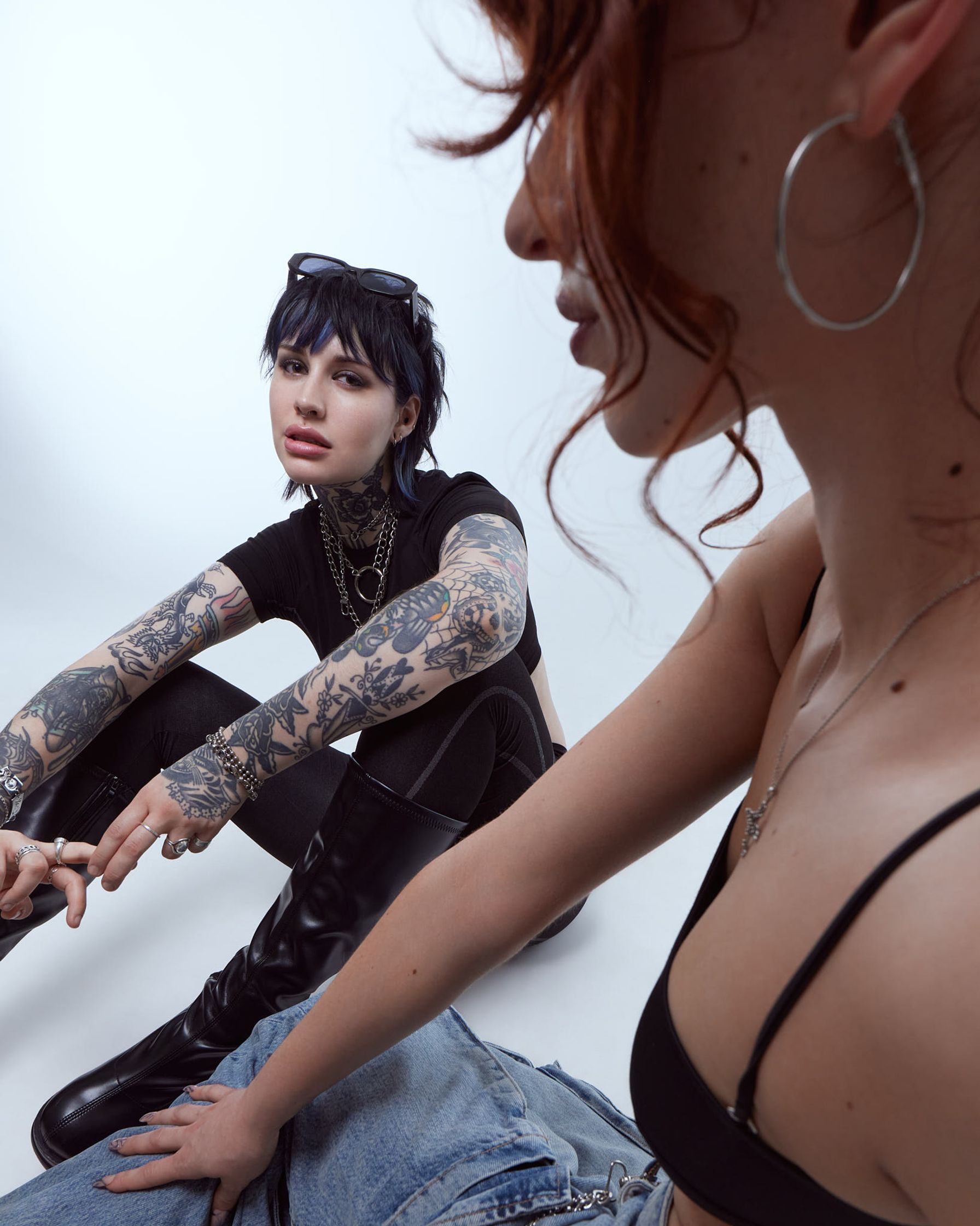 a woman with tattoos sitting on the floor