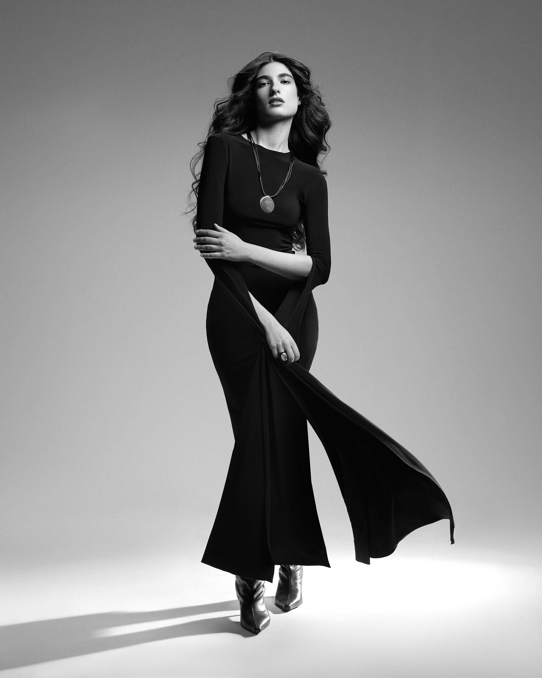 a woman in a black dress posing for a photo shoot