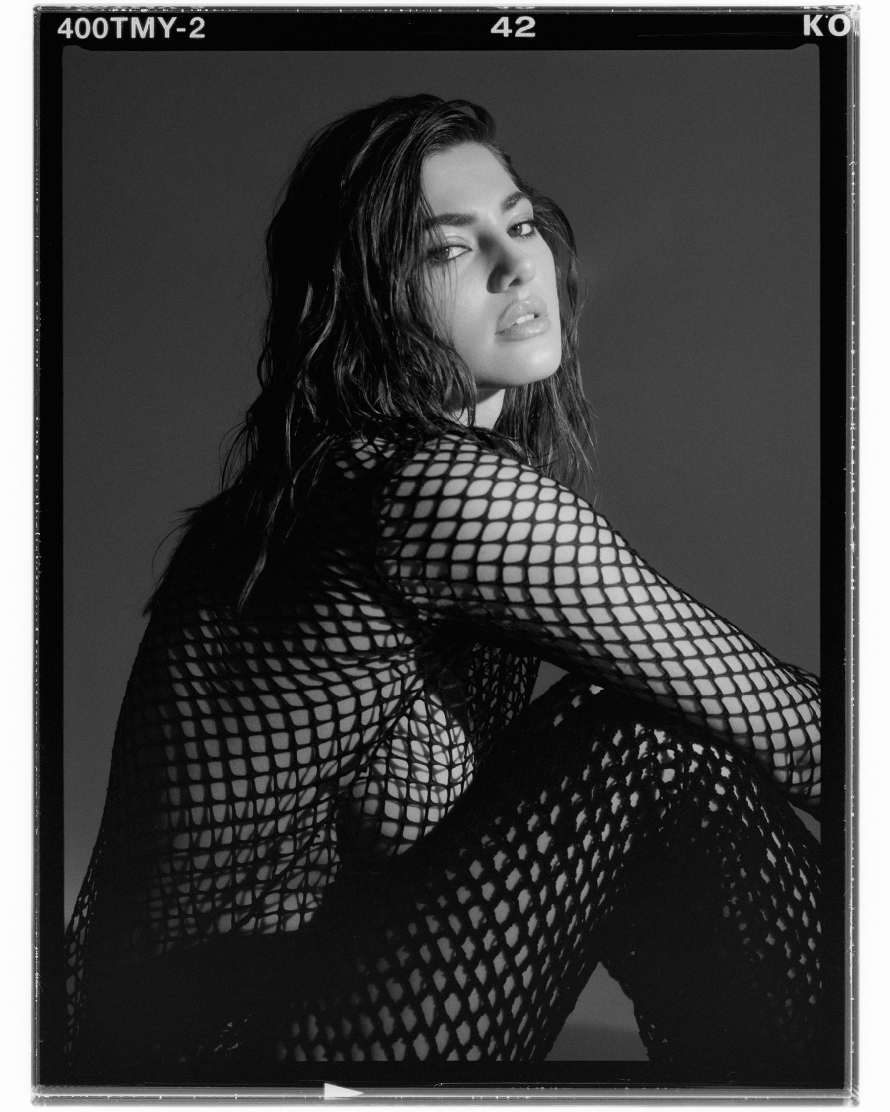 a black and white photo of a woman in fishnets