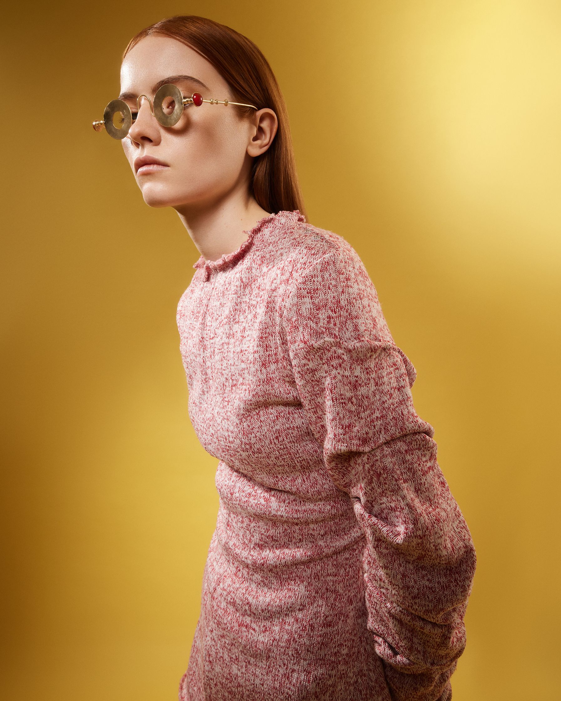 a young woman wearing glasses and a pink dress