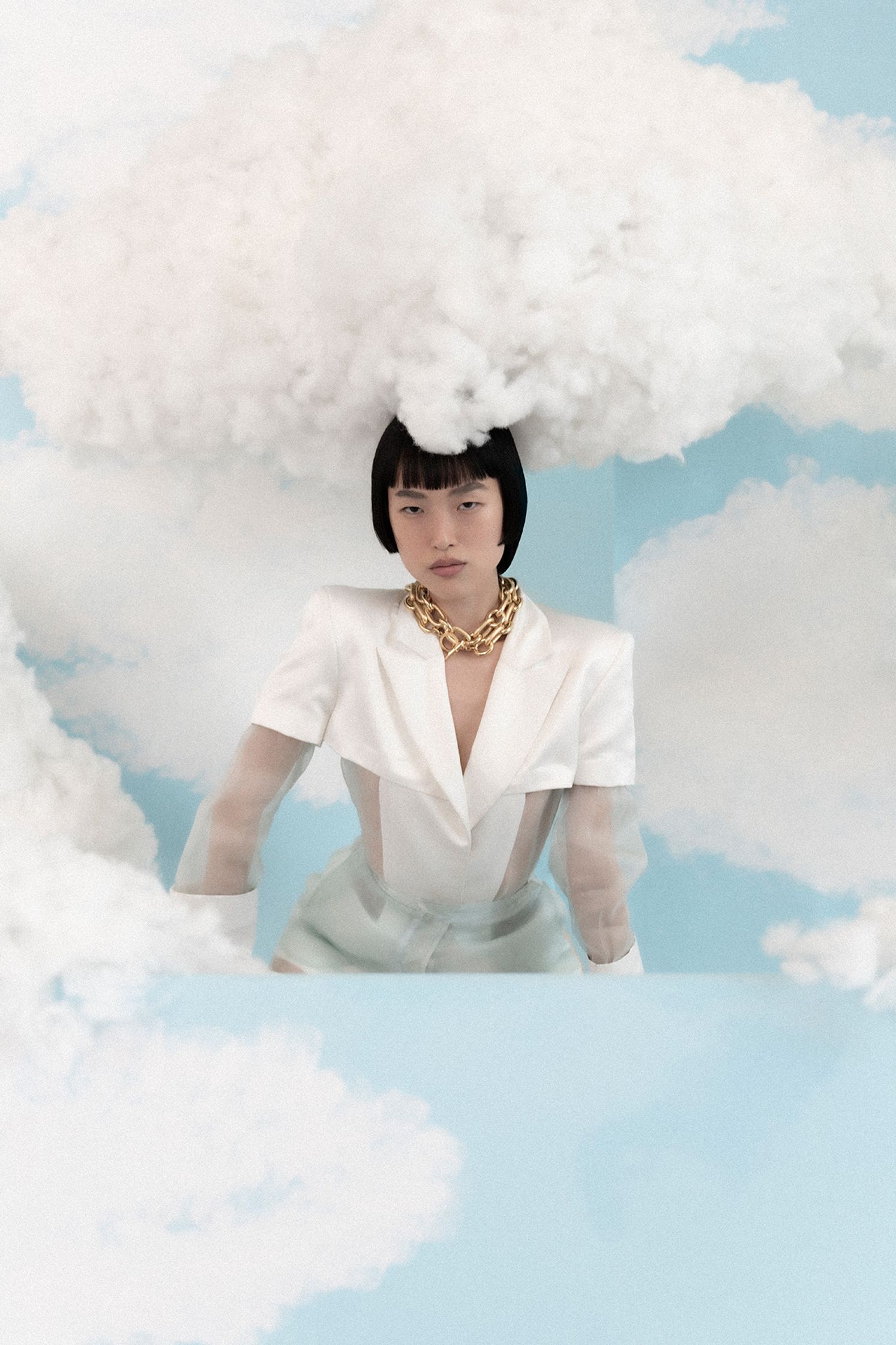 a woman in a white dress is sitting on top of a cloud