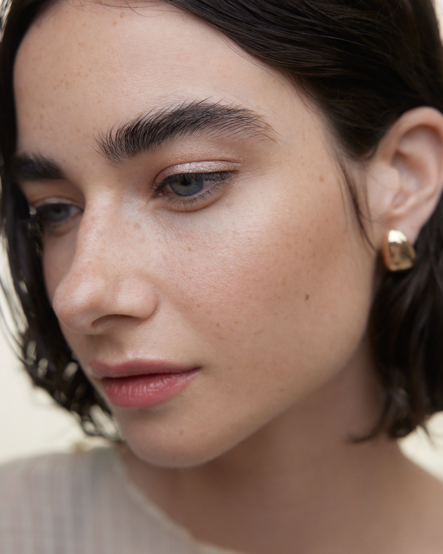a woman wearing a gold hoop earring