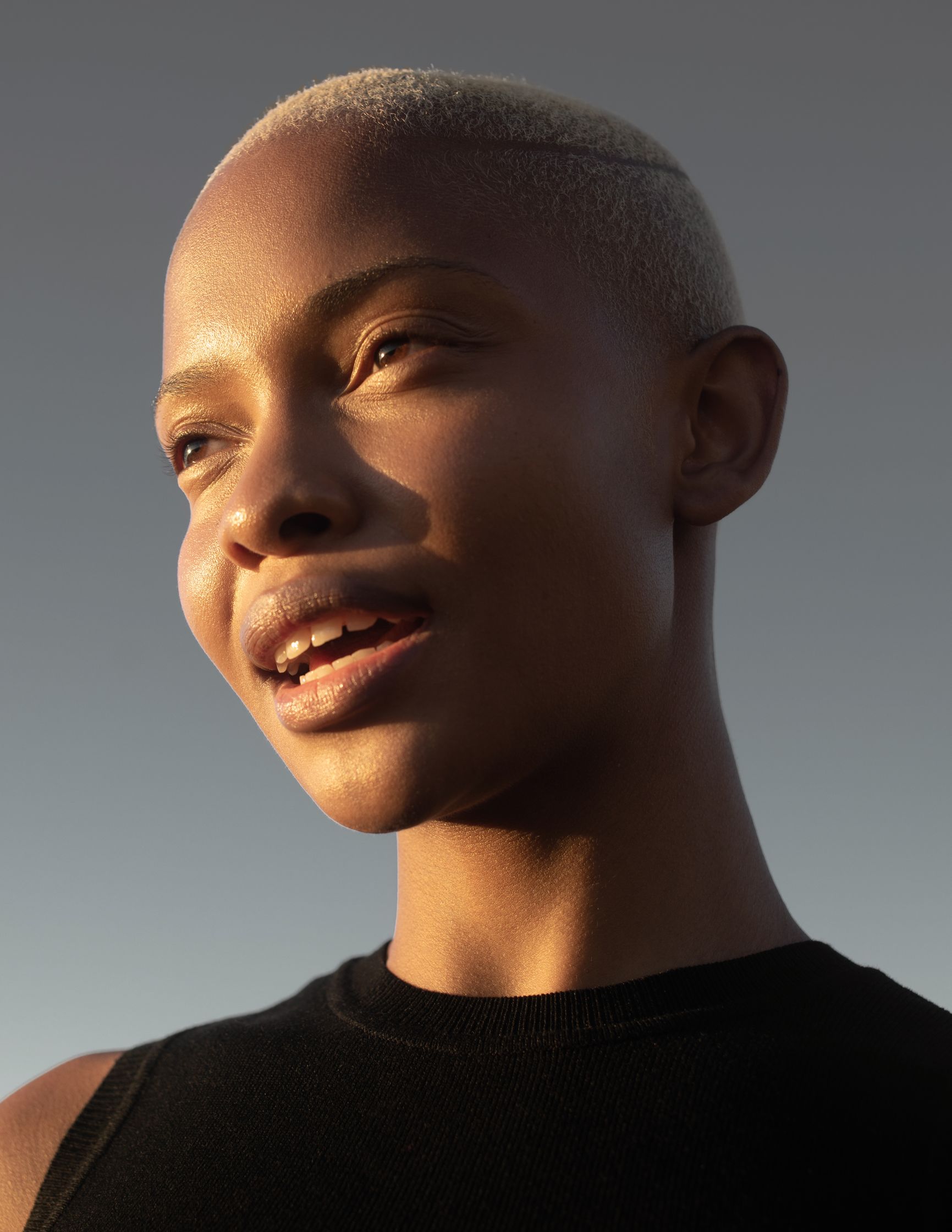 a black woman with a shaved head looking up at the sky