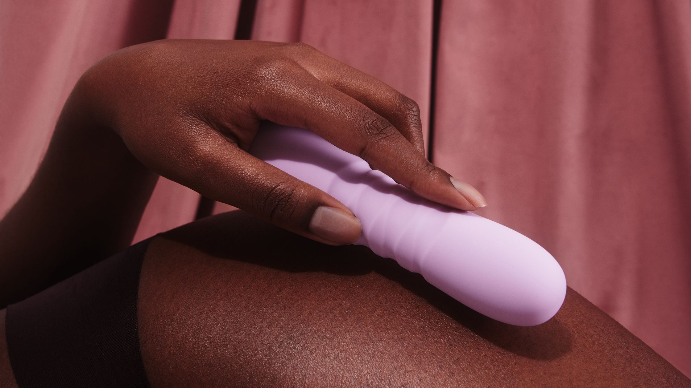a woman is holding a purple vibrating toy