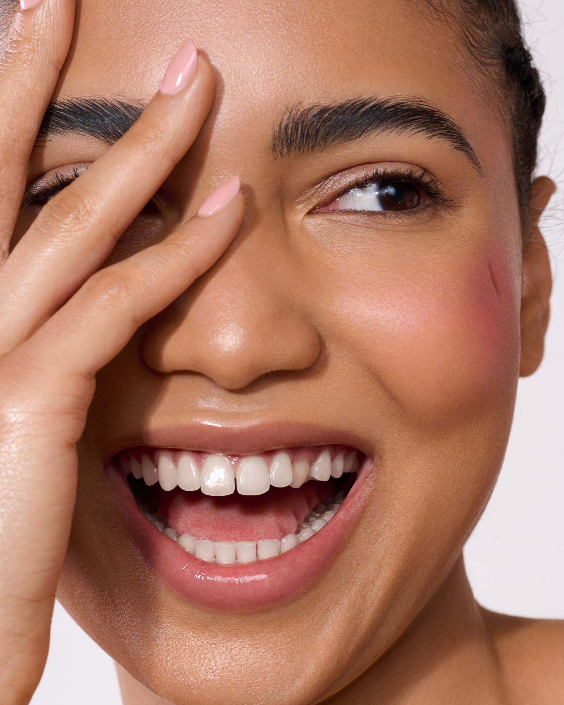 a woman is holding her hand up to her face