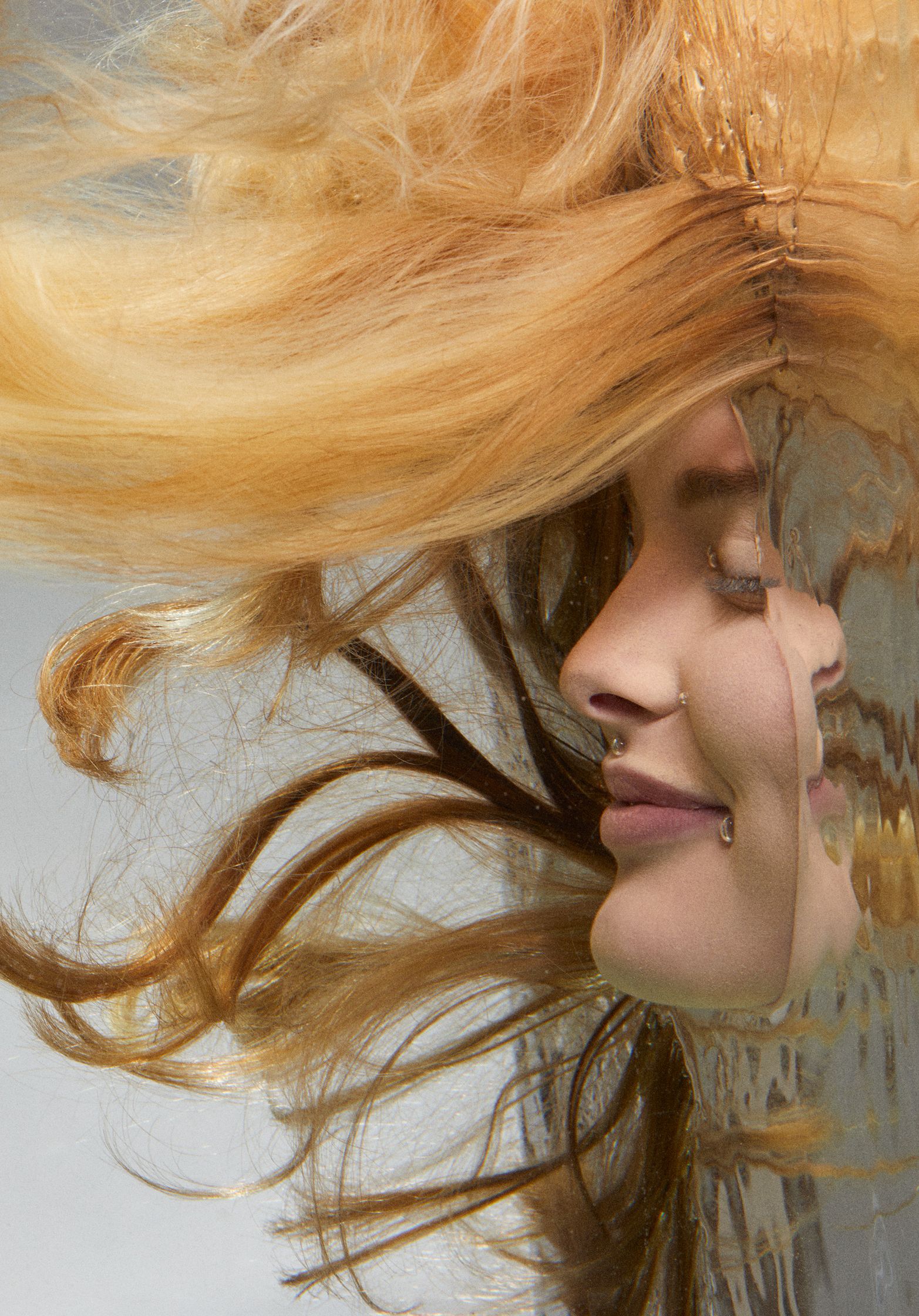 a woman's hair floating  in water , her face is half covered by water by photographer Frauke Fischer