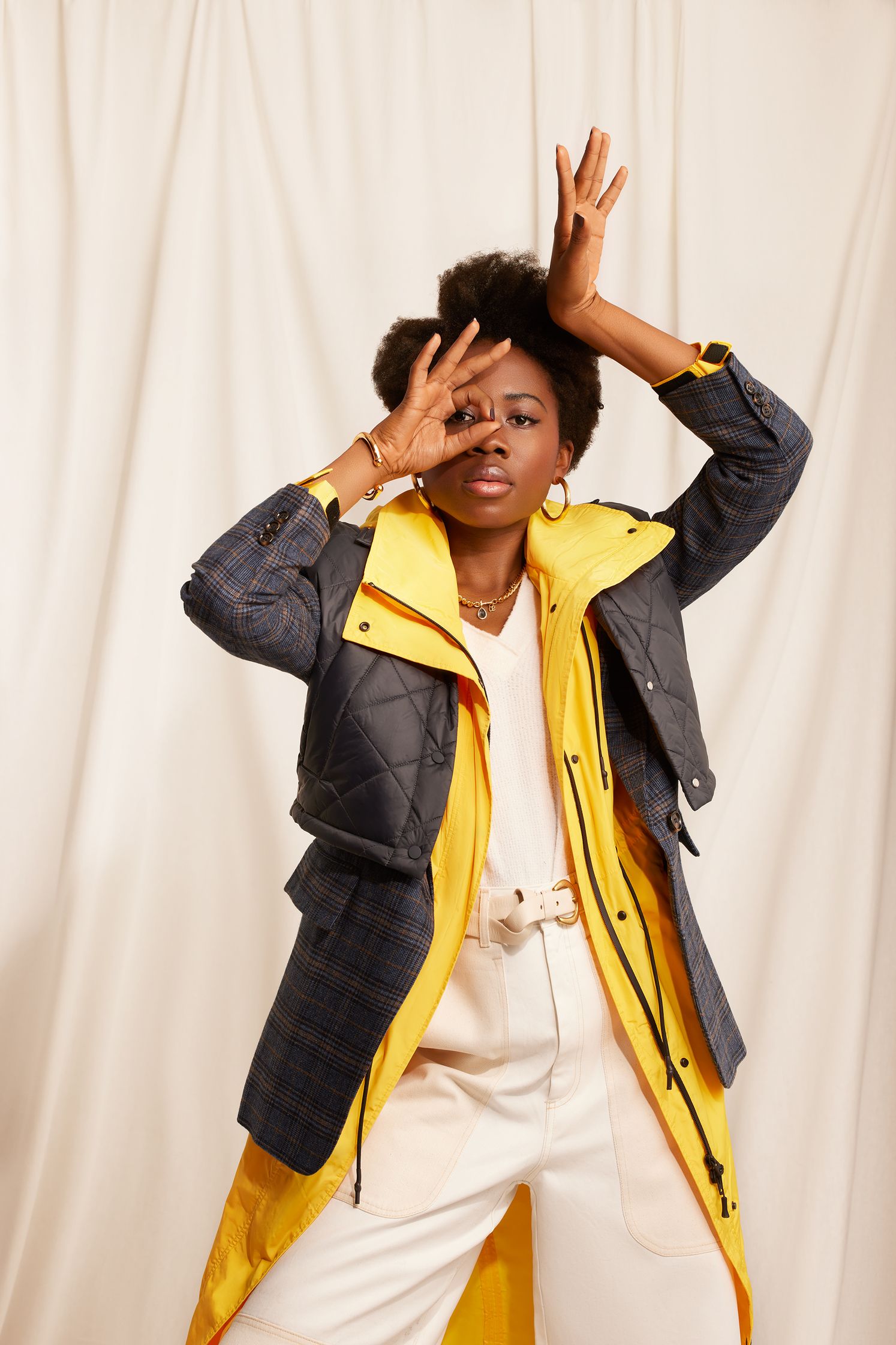 a black woman in a yellow jacket and white pants