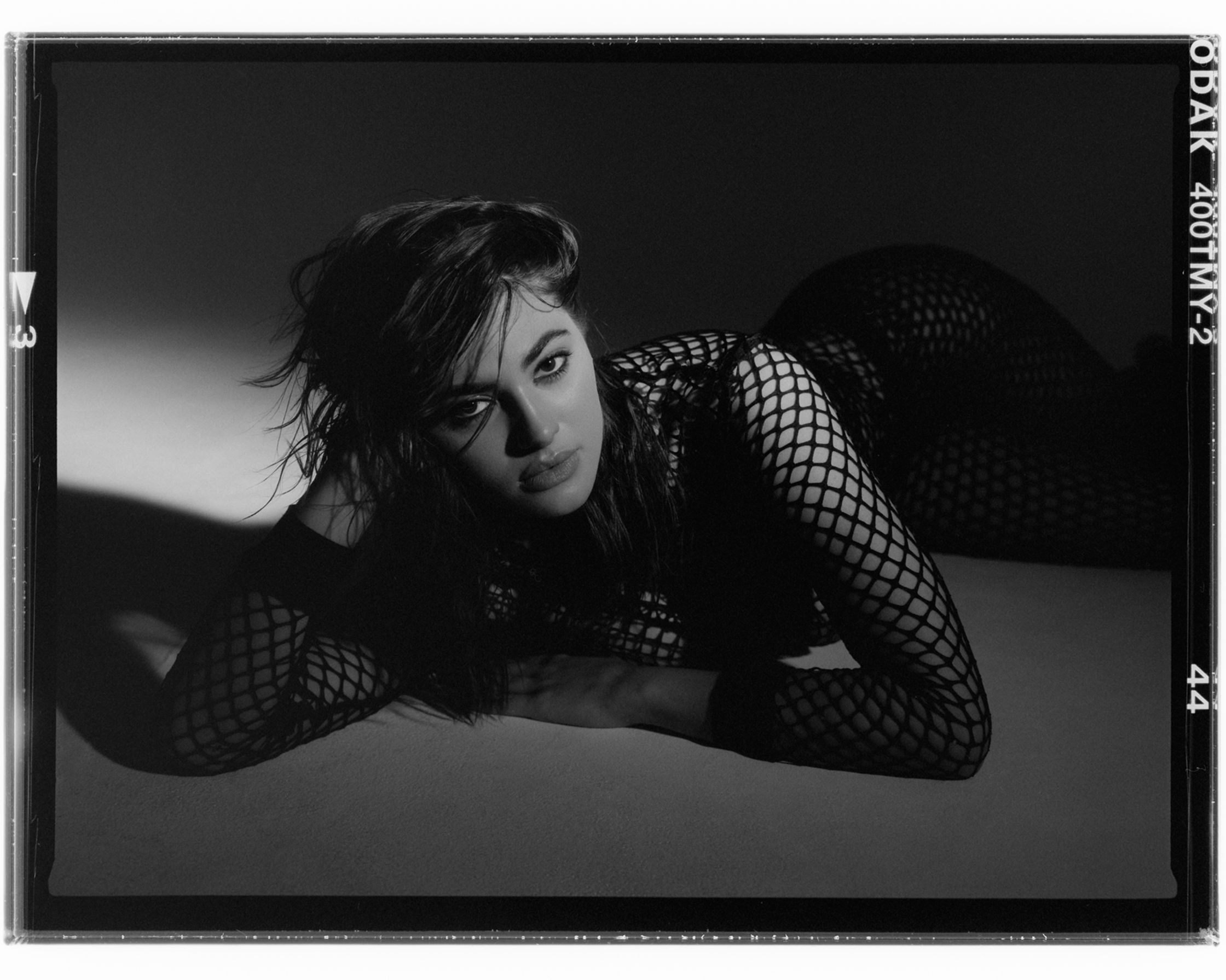 a black and white photo of a woman in fishnets