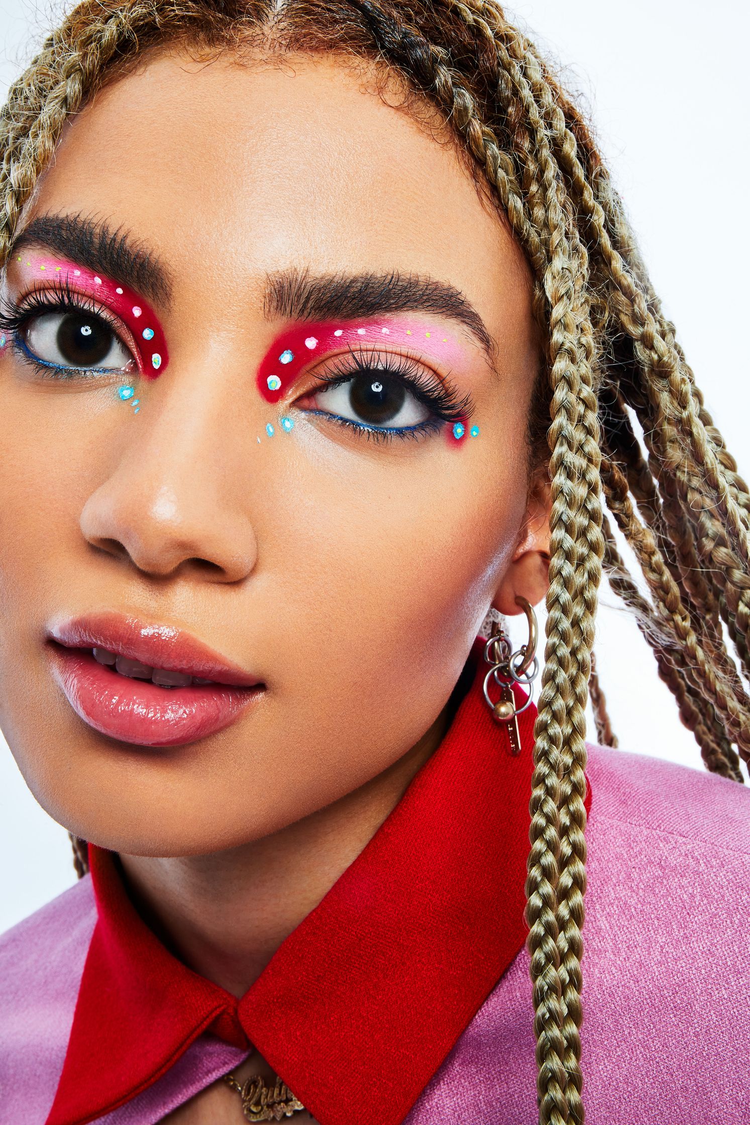 a woman with dreadlocks and colorful eye makeup