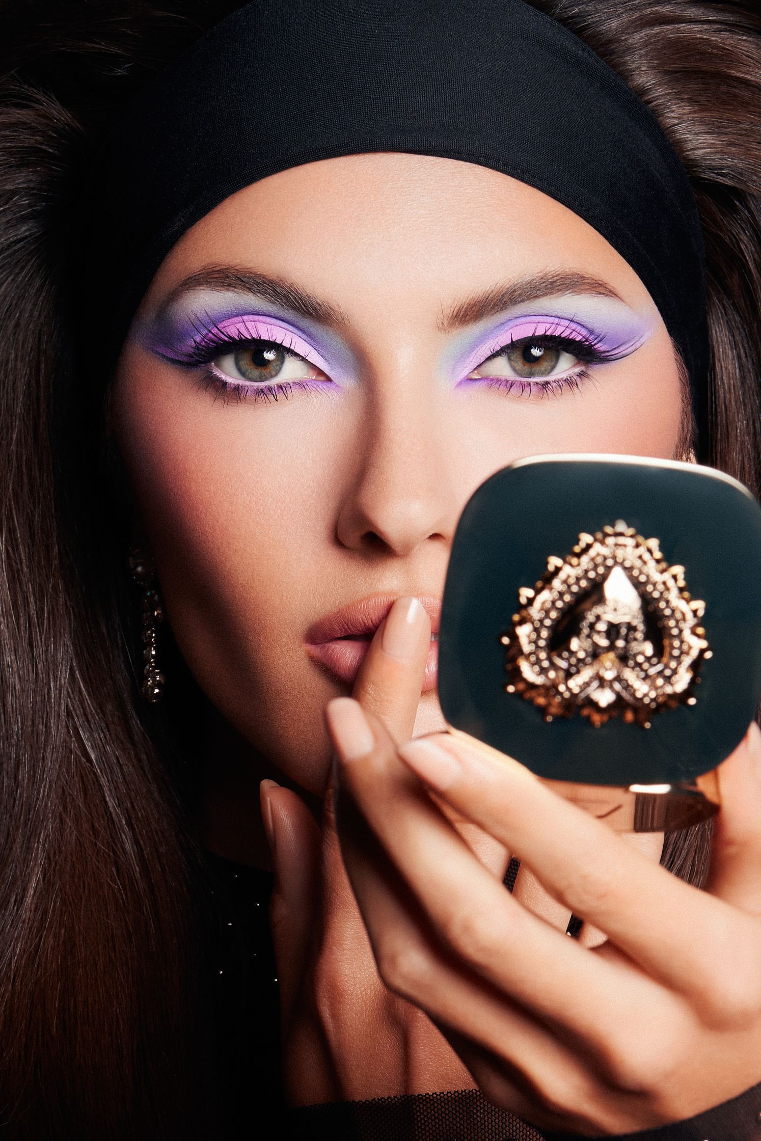 a woman holding a makeup compact in her hand