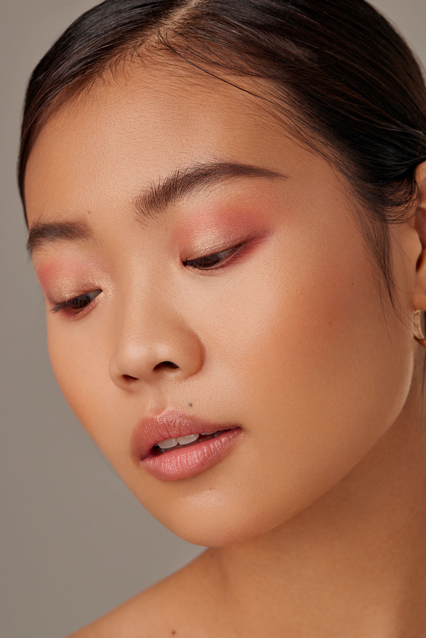 an asian woman with pink eye makeup