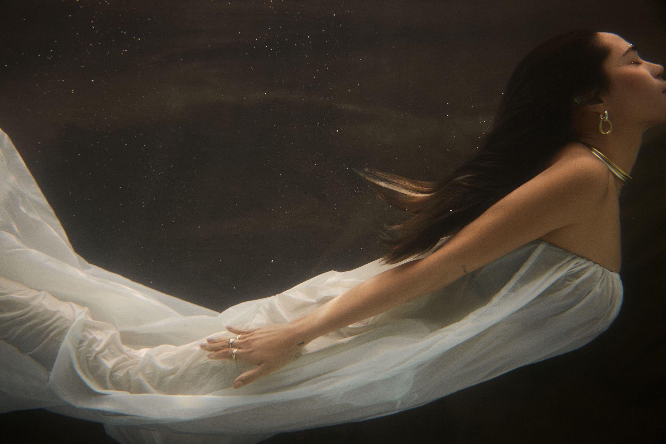 a woman in a white dress under water
