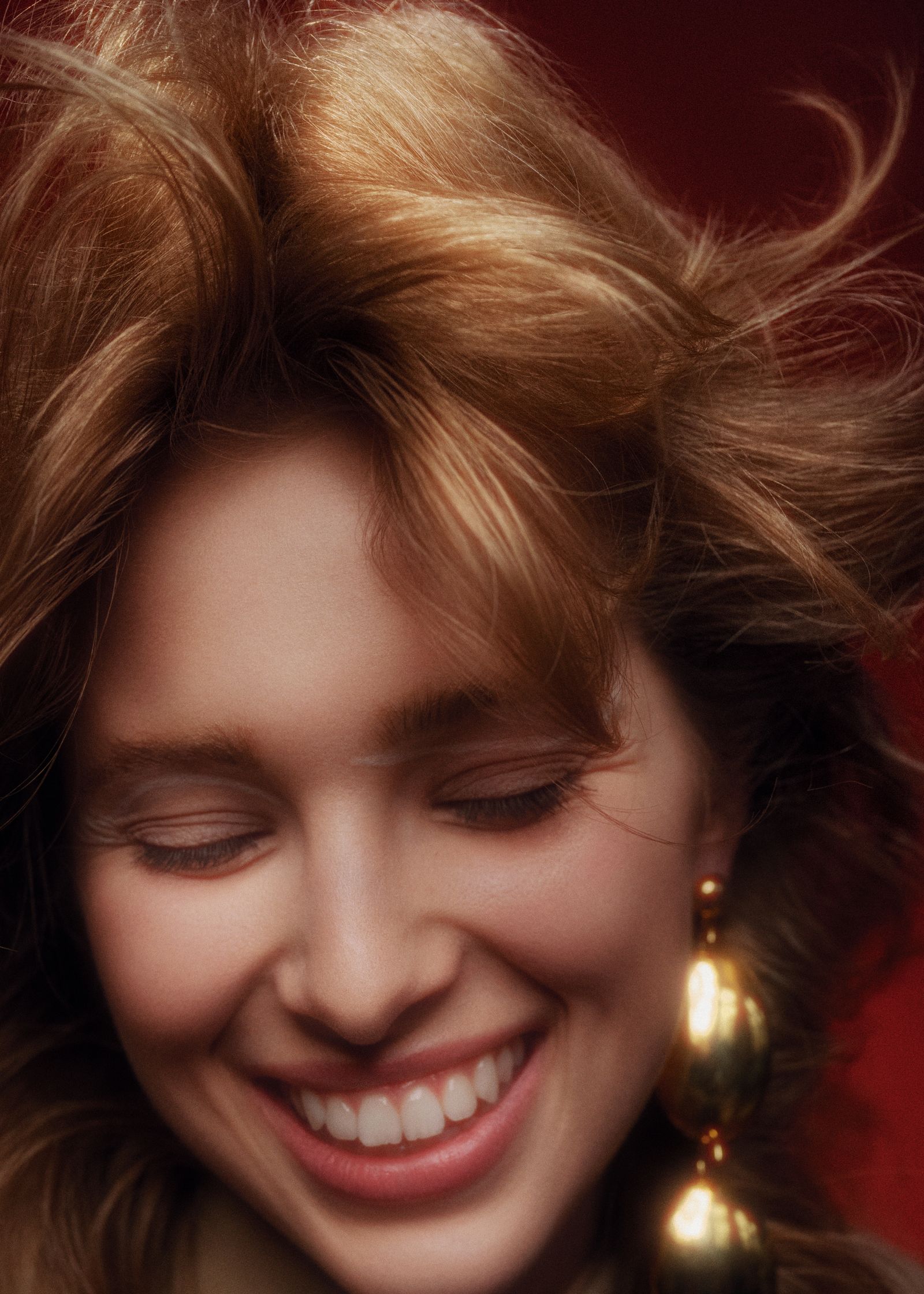 a woman smiling with her hair blowing in the wind