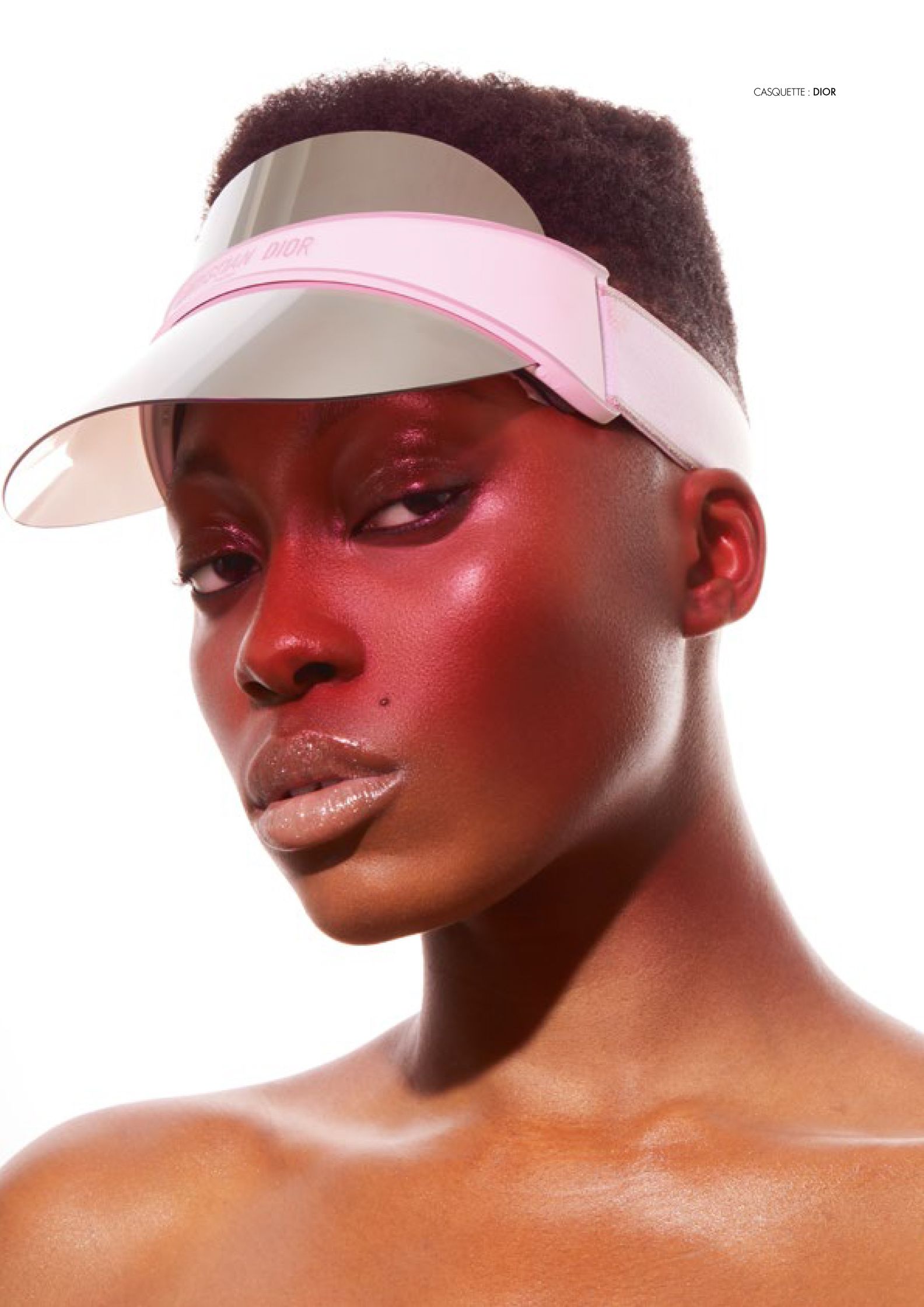 a black woman wearing a pink visor