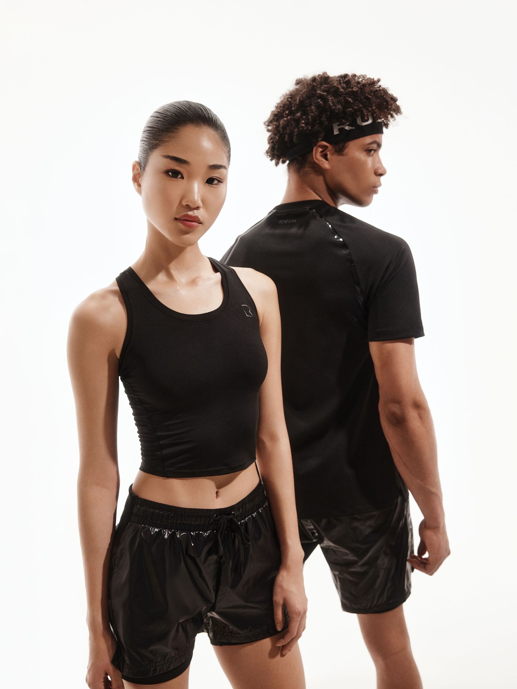 a man and woman wearing black shorts and a black tank top