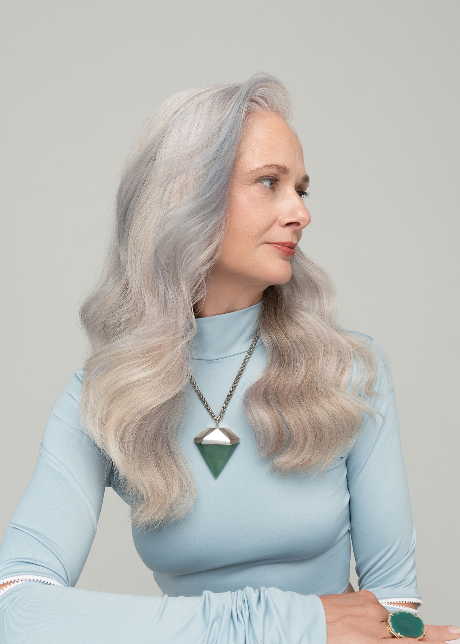 a woman with grey hair is posing for a photo