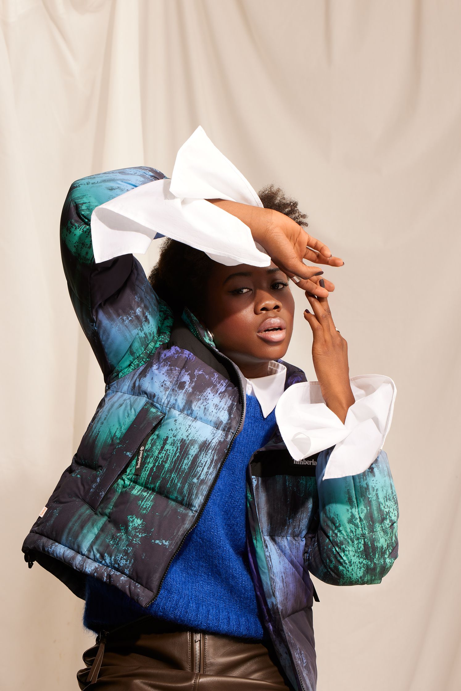 a young woman in a blue jacket posing for a photo