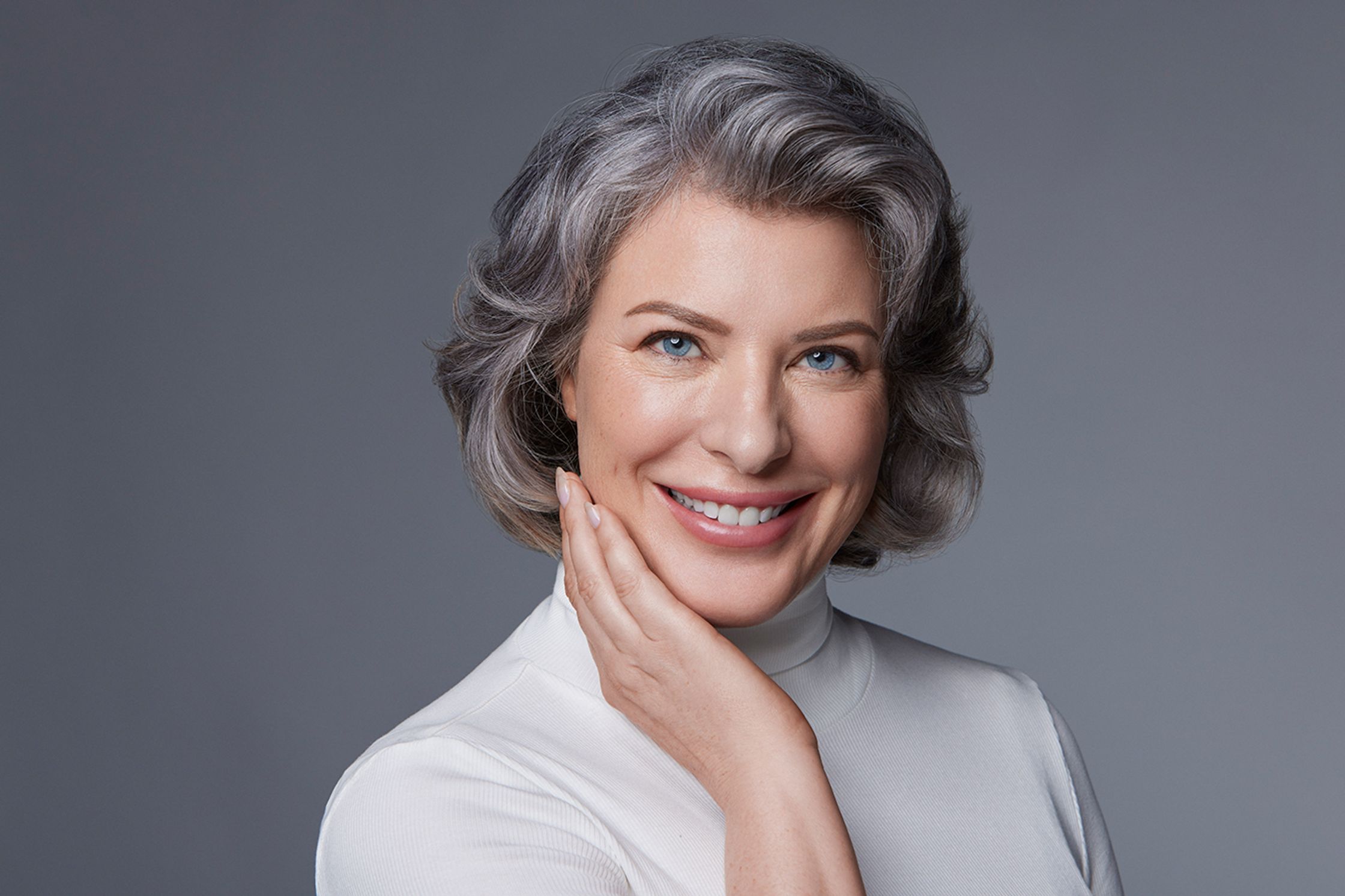 a woman with gray hair posing for a photo