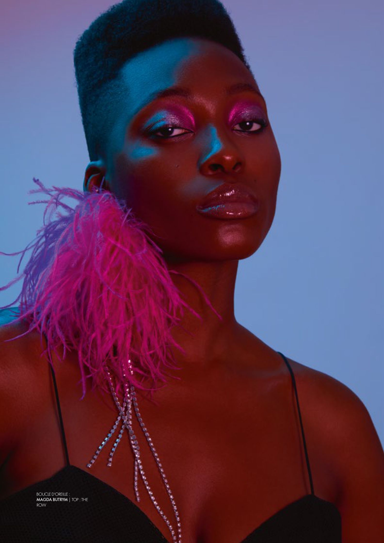 a black woman with pink feathers posing for a magazine