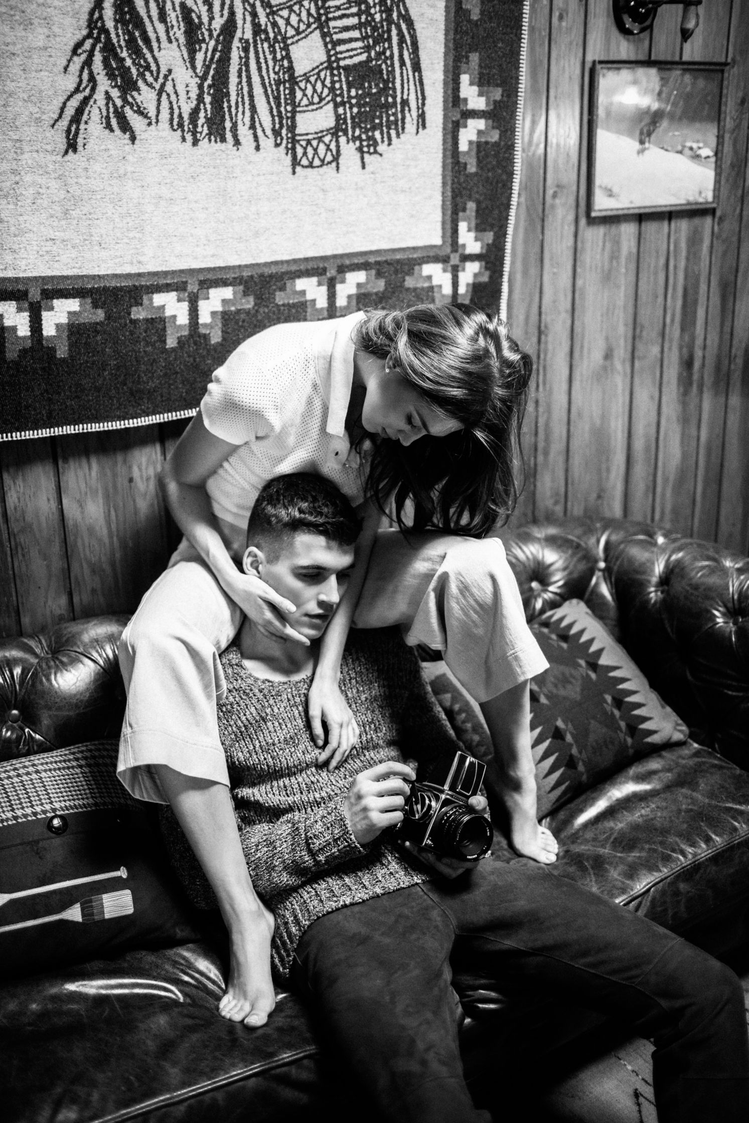 a black and white photo of a man and woman sitting on a couch