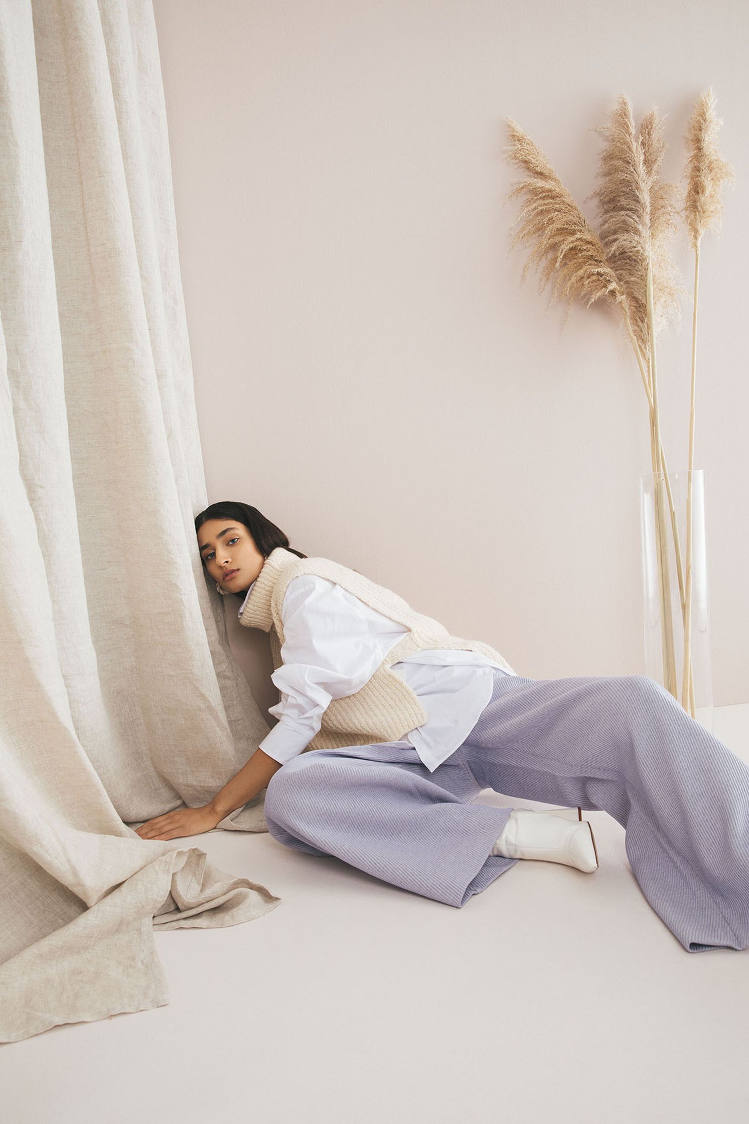 a woman laying on the floor next to a curtain